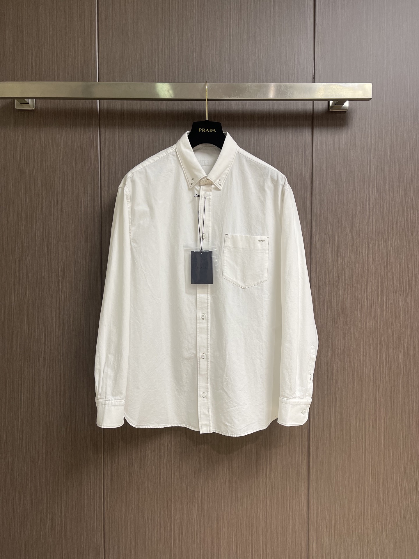 NO:847436,Prada embroidered chambray long-sleeve shirt  It is made of chambray cloth woven through plain weaving technology, which has a retro and relaxed texture. The cloth is light, soft and waxy, breathable and moisture-absorbent, making the upper body refreshing and not sweaty. At the same time, it has excellent drape, is anti-wrinkle, and is easy to take care of in daily life. The high-density weaving is wear-resistant and anti-pilling.  It is not easy to deform or turn white after being washed for a long time, it is comfortable against the skin, and the pattern is durable and neat. After the embroidery process is accurately vectorized and the pieces are precisely positioned and fixed, the Tajima embroidery machine is used to automatically move the stitches with precision; high-end embroidery threads have even tension, fine and full stitches, and no  There is no missing thread in the jumper, forming an embroidery font with 5 letters in total and 542 stitches. Its edges are clean and three-dimensional, and it is resistant to washing without stripping or fading. The entire garment adopts exquisite contrasting color topstitching technology, and the line routing is clear and neat, forming a visual hierarchy with the body fabric to outline the garment.  Body contour. The whole car is double-threaded and tightly sewn, with even and solid stitches, and the splicing position is reinforced to prevent the seams from opening; the collar is shaped and hemmed, so it is crisp and does not collapse or deform. The cuffs, patch pockets, shoulder lines, and hems are all neatly pressed, and the seams are flat and anti-rolling. Sizes S-XL  46-52 46 code shoulder width 51 bust 118 length 76 48 code shoulder width 52 bust 122 length 77.5 50 size shoulder width 53 bust 126 length 79 52 size shoulder width 54 bust 130 length 80.5,,prada,shirts,19860909Prada 饰刺绣钱布雷长袖衬衫 采用通过平纹织造工艺编织而成的钱布雷布,自带复古松弛质感.布面轻薄软糯、透气吸湿,上身清爽不闷汗,同时垂坠感出色,抗皱,日常好打理.高密织造耐磨抗起球,久洗不易变形、不发白,贴肤舒适,版型持久利落.刺绣工艺精准矢量打版、裁片精准定位固定之后,通过田岛绣花机全自动精密走针；高配绣线张力均匀,针脚细密饱满,无跳线无漏线,形成5个字母共542针的绣花字体,其边缘干净立体,耐水洗不脱线、不褪色.整衣采用精致撞色明线工艺,走线清晰利落,和衣身面料形成视觉层次,勾勒衣身轮廓.全车双线密拷车缝,针脚均匀扎实,拼接位加固不易开线；领口定型包边,挺括不塌不变形.袖口、贴袋、肩线、下摆全线压线工整,锁边平整防卷边.尺码S-XL 46-52 46码 肩宽51 胸围118衣长76 48码 肩宽52胸围122衣长77.5 50码 肩宽53胸围126衣长79 52码 肩宽54胸围130衣长80.5,,prada,shirts,,Men's clothing