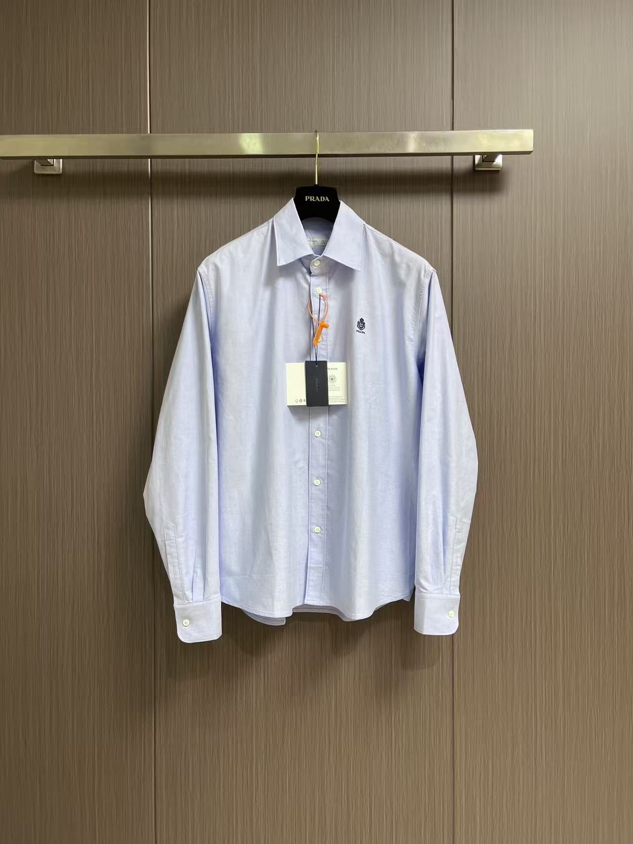NO:856301,Prada embroidered logo shirt. Customized luxurious and tough double weft Oxford fabric. Stiff and stylish. Comfortable and breathable. Made of soft moonlight-soaked white as the base. It outlines the essence of luxury. Square-inch logo embroidery on the chest. The stitching is as meticulous as weaving. The contrasting colors are the finishing touch. It condenses the elegant style. It strikes the right elegant balance between low-key restraint and avant-garde style. It adopts imported machine embroidery technology and uses advanced computer control systems and precision mechanical components to realize Prada embroidery operations with high precision.  The lines are smooth and delicate. The fabrics have been fermented and washed. They feel better and are not easy to deform, shrink or fade. They maintain long-term beauty. Sizes S-XL 39-40-41-42. Size 39, bust 116, shoulder width 47.5, length 74.5. Size 40, bust 120. Shoulder width 49.5, length 76. Size 41, bust 124, shoulder width 51.4.  Length 77.5, size 42 bust 128, shoulder width 53.5, length 79, prada, shirts,19860909Prada 刺绣徽标衬衫 定制奢韧双纬牛津纺 挺括有型 舒适透气 以温柔的月光浸白为底 勾勒高级感的本质 胸口方寸徽标刺绣 针脚缜密如织 撞色点睛成韵 凝练奢雅风骨 于低调内敛与先锋格调之间 拿捏恰到好处的优雅平衡 采用进口机刺绣工艺 使用先进的计算机控制系统和精密的机械部件 实现Prada刺绣作业 精度高 线条流畅而细腻 面料都经过酵洗 手感质感更佳 不易变形 不易缩水 不易褪色 保持长久的美观.尺码S-XL 39-40-41-42 39码胸围116肩宽47.5 衣长74.5 40码胸围120 肩宽49.5 衣长76 41码 胸围124 肩宽51.4 衣长77.5 42码胸围128 肩宽53.5 衣长79,,prada,shirts,,Men's clothing