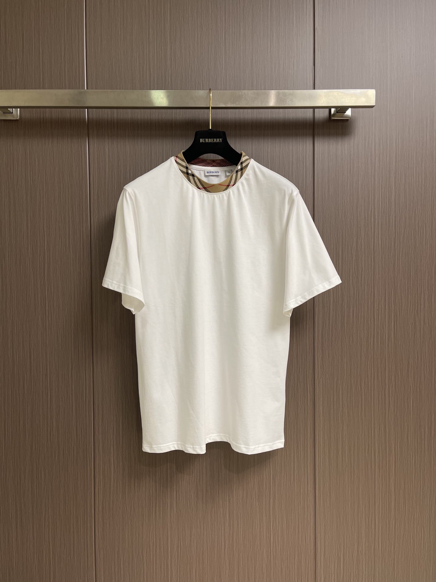 NO:875338,Burberry  Round neck plaid decorated cotton T-shirt. This T-shirt selects 230g high-count long-staple cotton as the core fabric. It is combed to remove impurities and hairiness. The fabric surface is smooth and delicate and feels soft and skin-friendly. It is equipped with pre-shrinking technology to ensure stable size of the garment and long-lasting washing.  It is not easy to shrink and deform, and has excellent breathability, perspiration and anti-wrinkle properties, suitable for daily commuting and light leisure scenes. The body adopts a classic loose shoulder style, with neat and casual tailoring, and no sense of restriction when moving; the neckline technology is the highlight of the design, and the built-in high-density color scheme is the same color  High-strength rib reinforcement, the outer layer is spliced with the brand's iconic Vintage plaid jacquard webbing, the color level is clear and the three-dimensional effect is strong, effectively improving the recognition and wear resistance of the neckline. The key seams are reinforced with double-strand open stitching technology, and the hem and cuffs are locked  The edge processing not only ensures the stability of the version, but also reduces skin friction. The overall craftsmanship perfectly combines the comfort of the basic style with the luxury of the classic plaid. The details are exquisite, showing the quality of high-end ready-to-wear. The overall wiring is straight and delicate, the fabric is comfortable and soft, and the color is consistent without color difference.  It can be matched with the same style to create a fashionable look, and can be used in various occasions. Customized accessories, complete with three standards, same style for men and women!  Size S-XL S size Bust 100 Shoulder width 47 Length 66 Medium Bust 106 Shoulder width 48 Length 68 L size Bust 112 Shoulder width 49 Length 7019860909Burberry 圆领格纹装饰棉质T恤,本款T恤甄选230g高支长绒棉作为核心面料,经精梳工艺去除杂质与毛羽,织面平整细腻且触感软糯亲肤,搭配预缩水处理技术,确保成衣尺寸稳定,久洗不易缩水变形,同时具备优异的透气排汗与抗皱性能,适配日常通勤与轻休闲场景.衣身采用经典宽松落肩版型,剪裁利落随性,活动无束缚感；领口工艺为设计亮点,内置同色系高密度罗纹加固,外层拼接品牌标志性Vintage格纹提花织带,色彩层次清晰且立体感强,有效提升领口辨识度与耐磨损度.关键接缝处采用双股明线加固平缝工艺,下摆与袖口做锁边处理,既保障版型稳固,又减少肌肤摩擦.整体工艺将基础款的舒适与经典格纹的奢华感完美融合,细节考究,尽显高端成衣品质.整体走线平直细腻,面料舒适柔软,颜色一致无色差 能与同款搭配营造时尚造型,驾驭各种场合,定制辅料,三标齐全,男女同款！尺码S-XL S码 胸围100 肩宽47 衣长66 M码胸围106 肩宽48 衣长68 L码 胸围112肩宽49 衣长70 XL码 胸围118肩宽50 衣长72,,burberry,tees，t-shirt,,Men's clothing