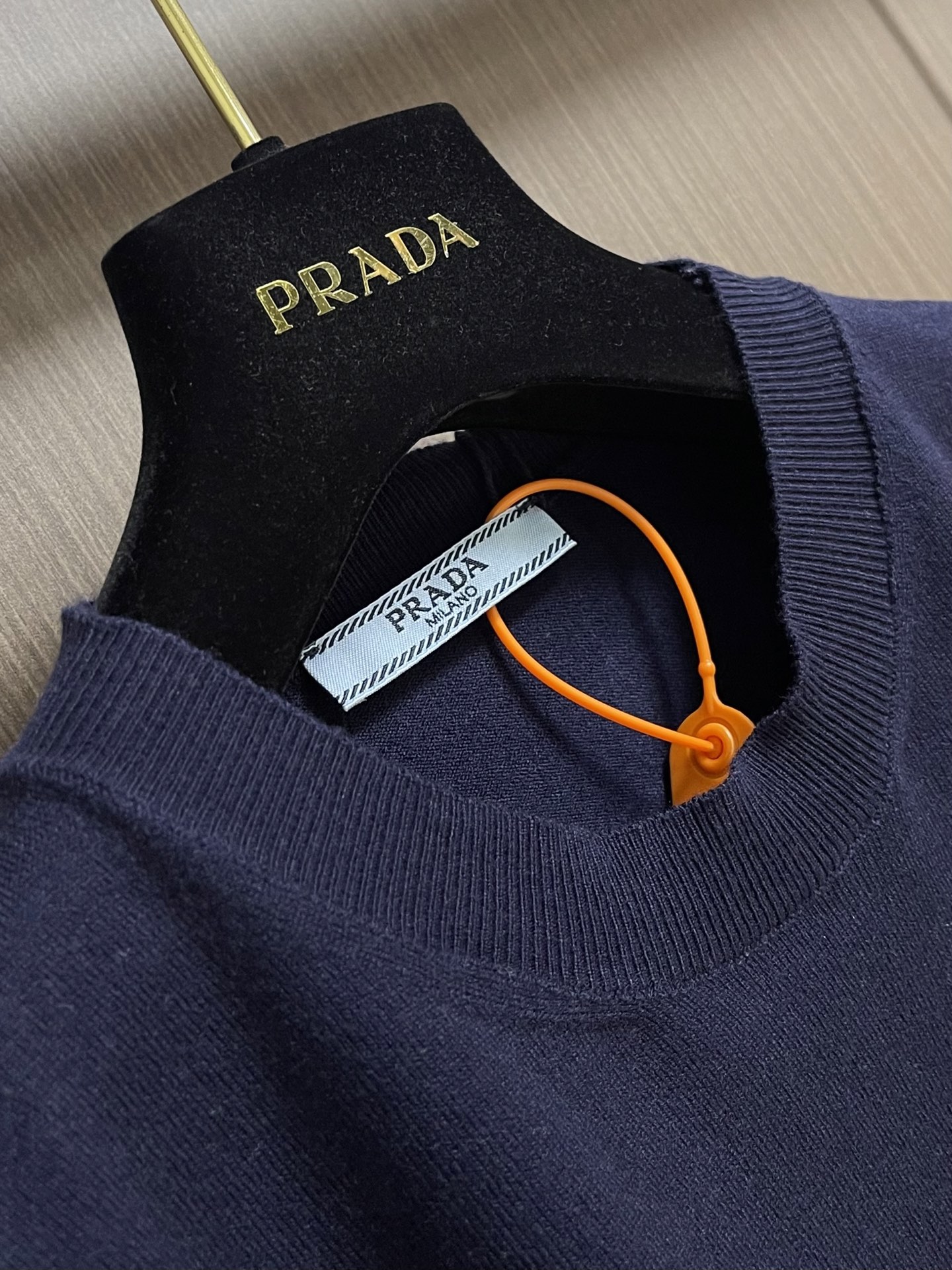 Prada 徽标嵌花圆领短袖针织毛衣，定织柔滑双股高密棉毛纱，柔软蓬松，舒适贴肤。以低饱和苋菜黄为基调，