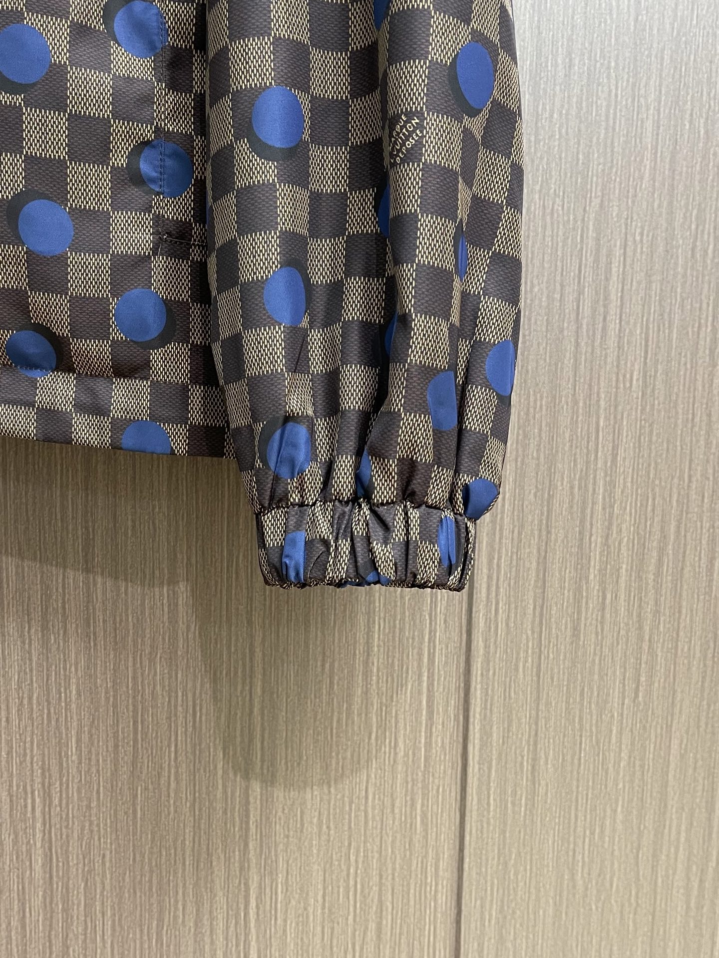 LV 波点棋盘格防风外套，本款防水防风夹克以醒目的 Damier 波尔卡圆点图案点亮夏日造型。科技面料呈
