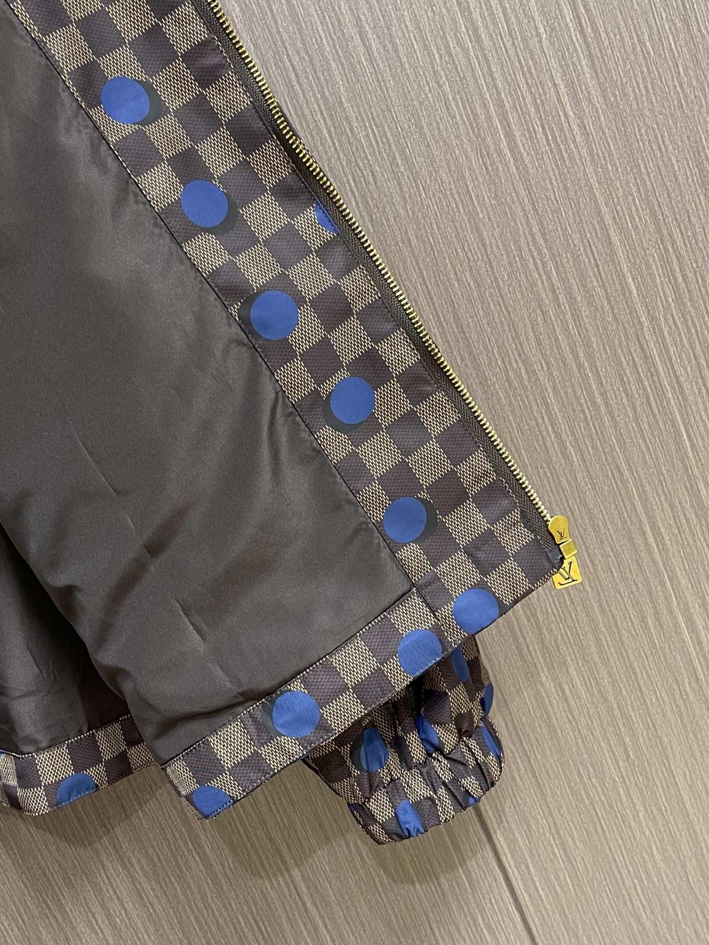 LV 波点棋盘格防风外套，本款防水防风夹克以醒目的 Damier 波尔卡圆点图案点亮夏日造型。科技面料呈