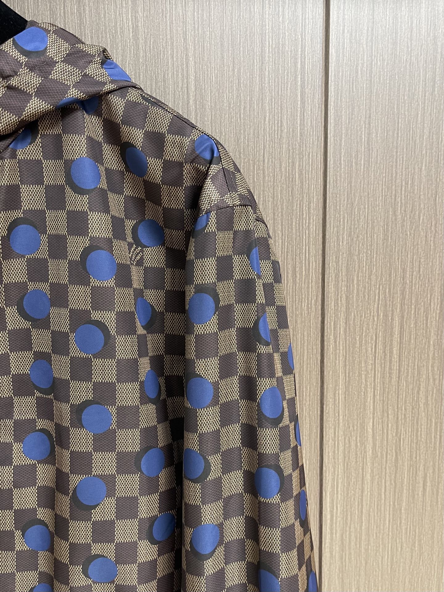 LV 波点棋盘格防风外套，本款防水防风夹克以醒目的 Damier 波尔卡圆点图案点亮夏日造型。科技面料呈