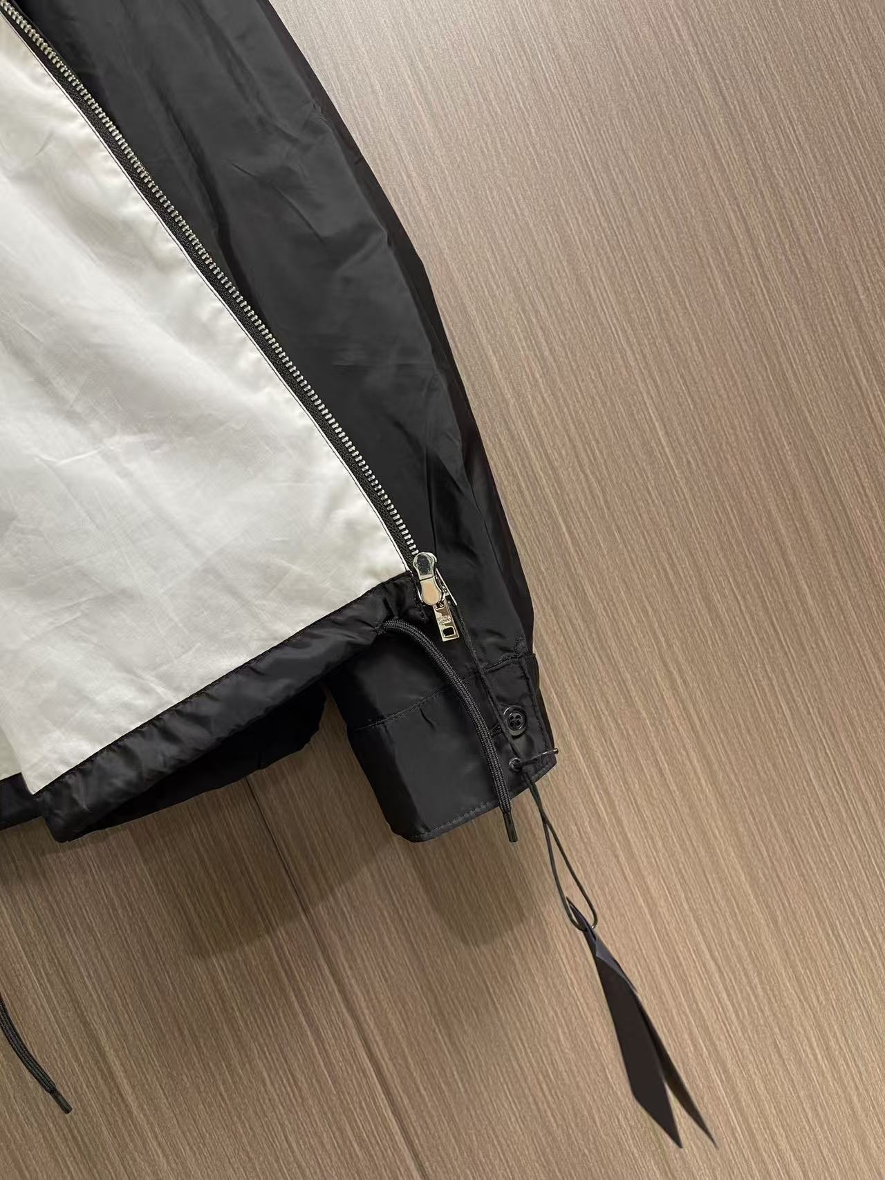 Prada 饰标翻领小外套，精选高密织造尼龙面料，纤维肌理紧实饱满，整体质地轻盈轻薄，上身零负重。面料经