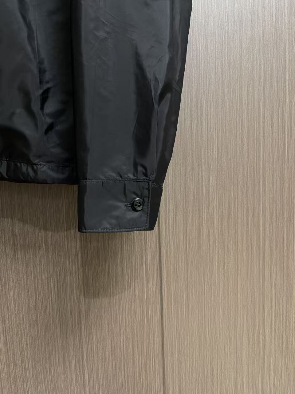 Prada 饰标翻领小外套，精选高密织造尼龙面料，纤维肌理紧实饱满，整体质地轻盈轻薄，上身零负重。面料经