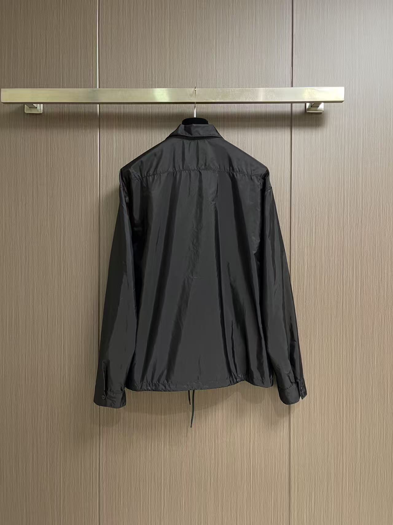 Prada 饰标翻领小外套，精选高密织造尼龙面料，纤维肌理紧实饱满，整体质地轻盈轻薄，上身零负重。面料经