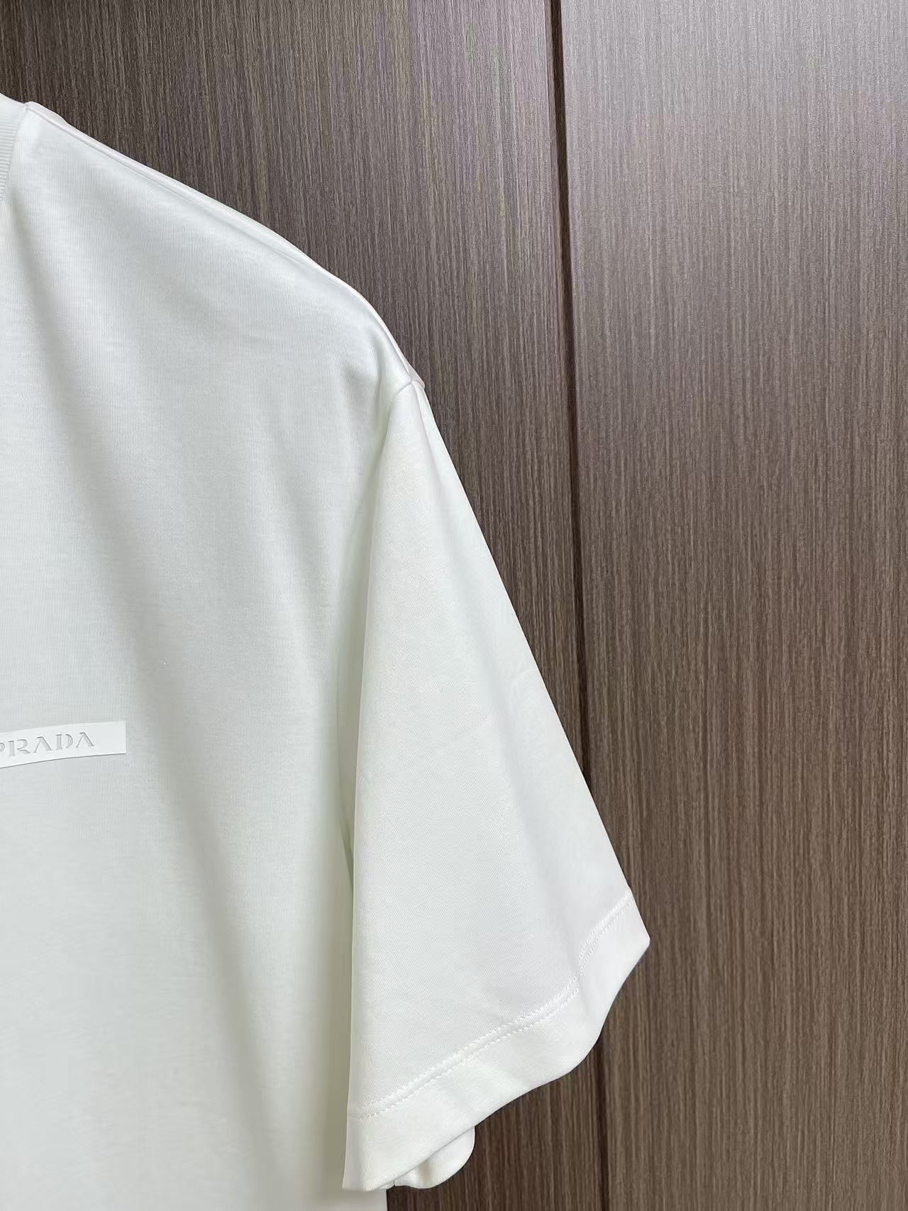Prada 胶印字母logo标识短袖T恤，平纹针织T恤秉承品牌简约而华美的理念，已然演变为一种态度，一种
