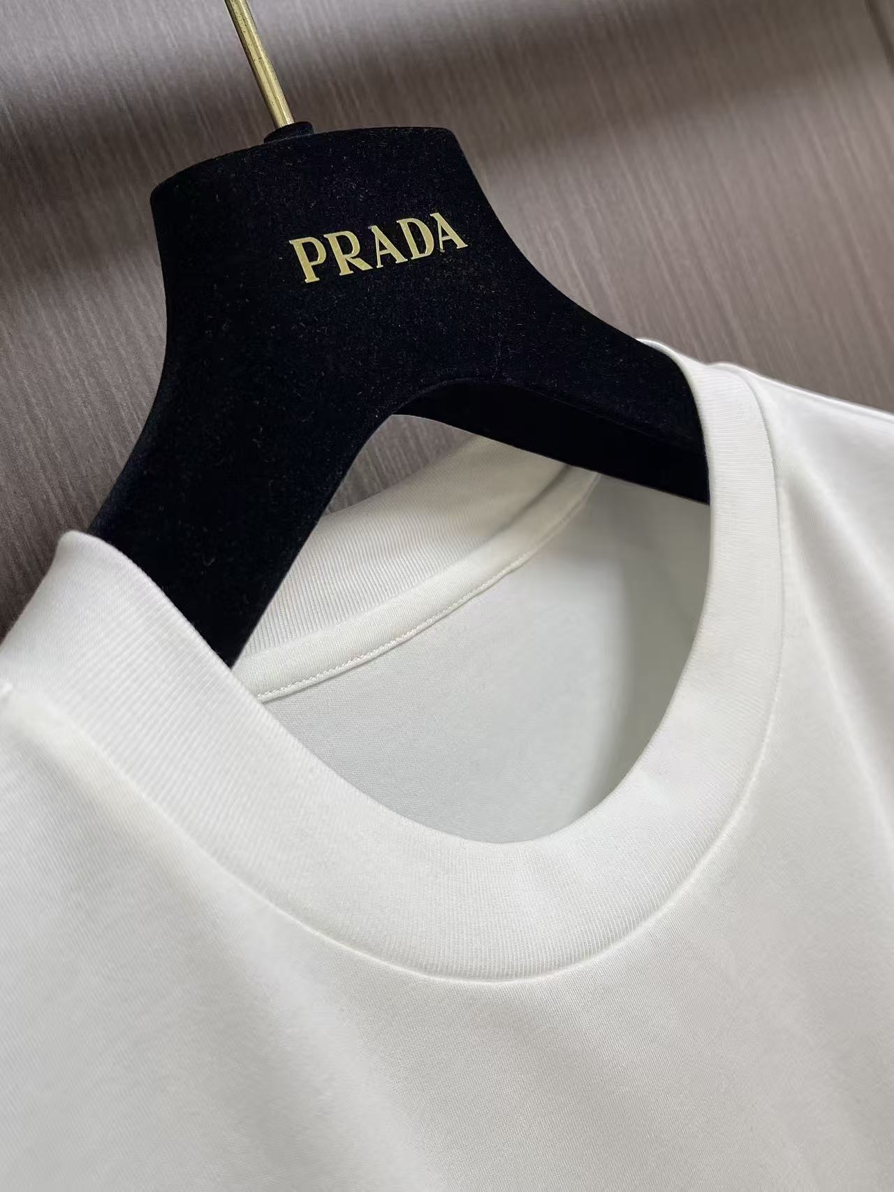 Prada 胶印字母logo标识短袖T恤，平纹针织T恤秉承品牌简约而华美的理念，已然演变为一种态度，一种