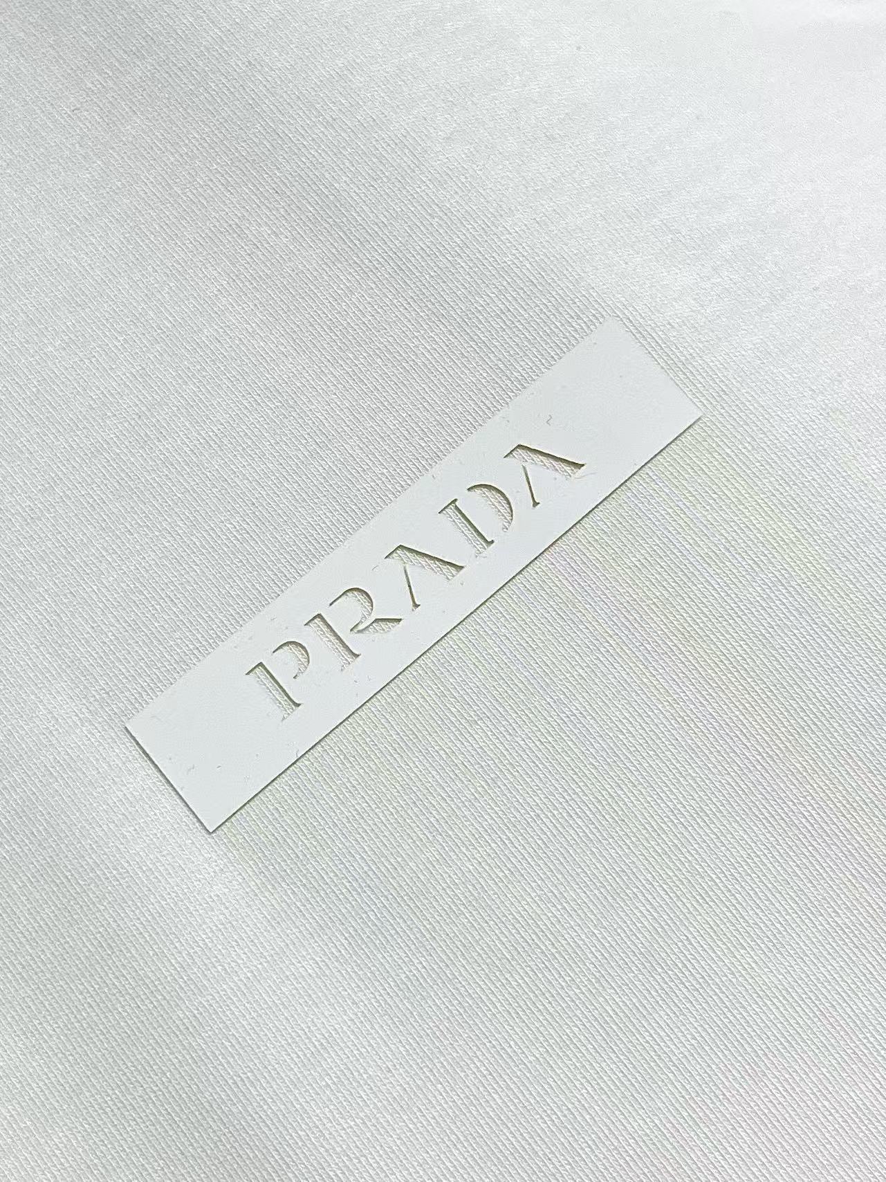 Prada 胶印字母logo标识短袖T恤，平纹针织T恤秉承品牌简约而华美的理念，已然演变为一种态度，一种