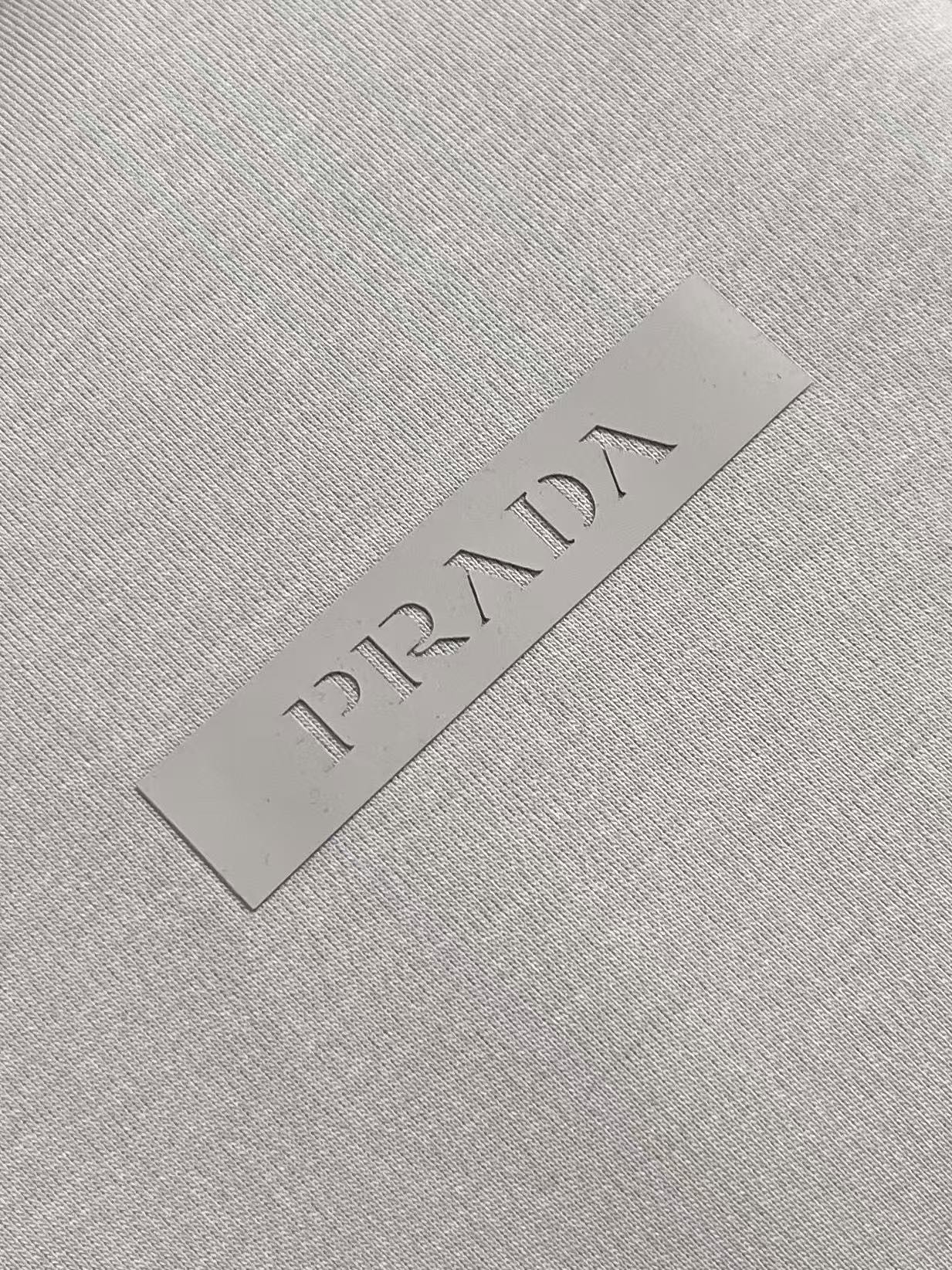 Prada 胶印字母logo标识短袖T恤，平纹针织T恤秉承品牌简约而华美的理念，已然演变为一种态度，一种