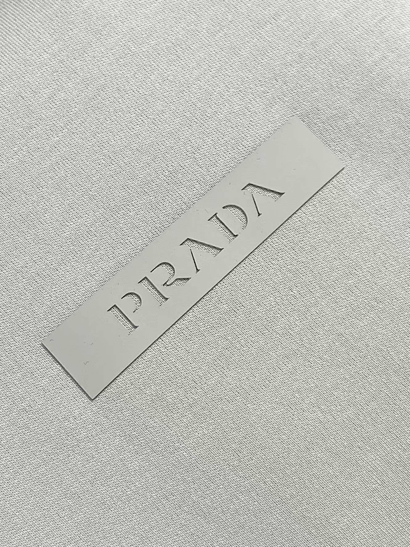 Prada 胶印字母logo标识短袖T恤，平纹针织T恤秉承品牌简约而华美的理念，已然演变为一种态度，一种