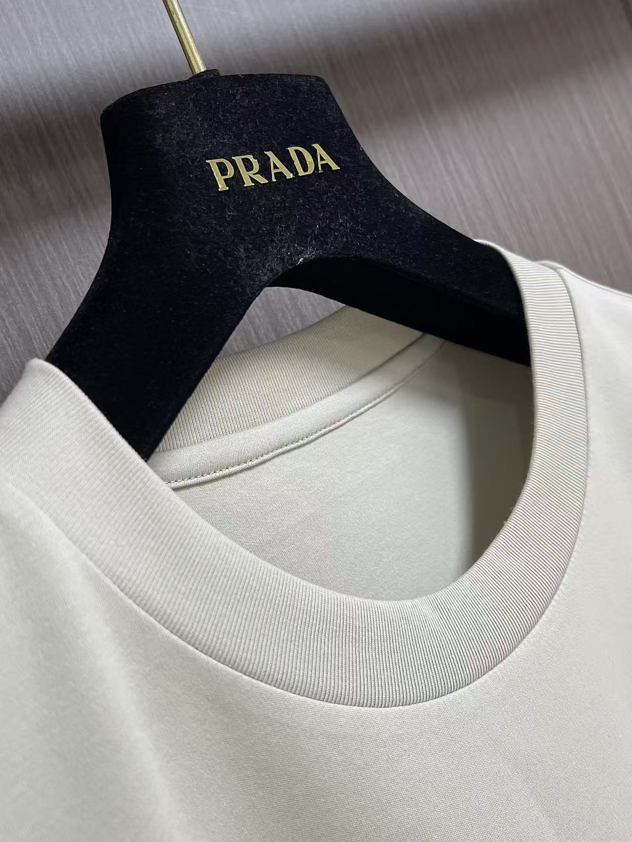 Prada 胶印字母logo标识短袖T恤，平纹针织T恤秉承品牌简约而华美的理念，已然演变为一种态度，一种