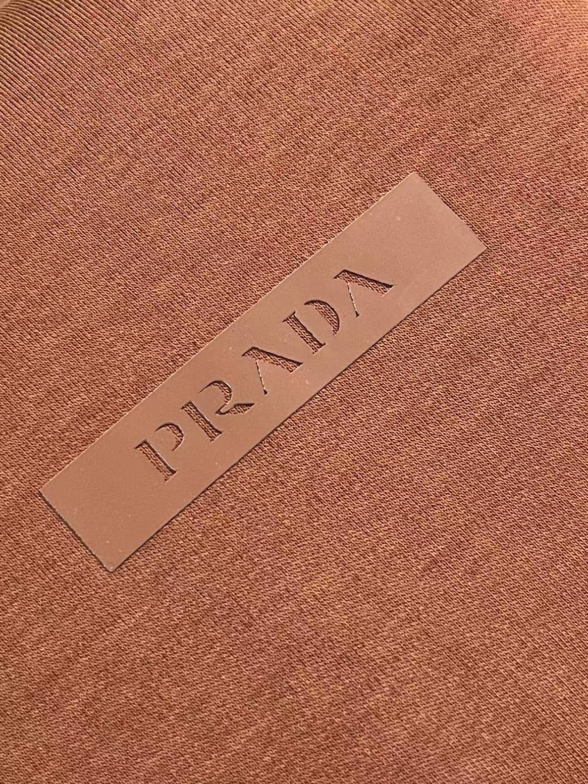Prada 胶印字母logo标识短袖T恤，平纹针织T恤秉承品牌简约而华美的理念，已然演变为一种态度，一种