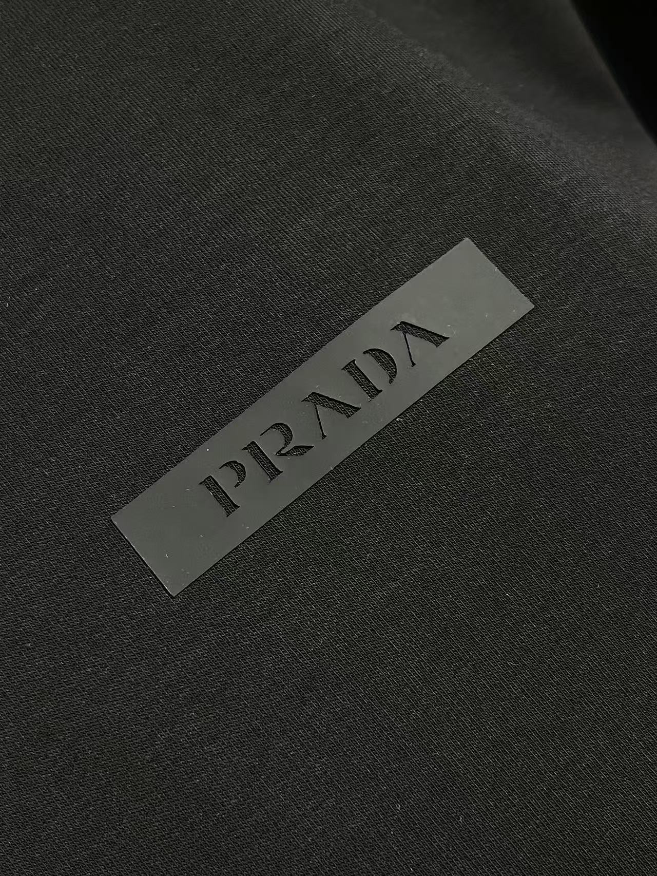 Prada 胶印字母logo标识短袖T恤，平纹针织T恤秉承品牌简约而华美的理念，已然演变为一种态度，一种