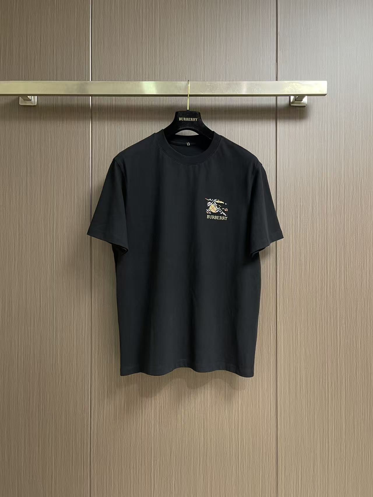 NO:903920,Burberry  Checkered war horse pattern cotton round neck short-sleeved T-shirt, this Burberry brand short-sleeved T-shirt is made of high-quality pure cotton fabric. The texture is soft and delicate, breathable and skin-friendly, with good drape and stiffness. It is comfortable to wear and not easy to deform. The classic brand logo and war horse pattern on the chest are made with precision embroidery technology. The stitching is fine and tight, and the pattern is three-dimensional and full, restoring the brand.  Iconic design texture. The round neck uses reinforced hemming technology, and the stitching is smooth and neat, so it will not become loose after long-term wear; the cuffs and hem are finely stitched, and the workmanship is rigorous and elegant. The overall shape is loose and neat, the turning lines are even and smooth, and the details show the brand's ingenious craftsmanship, taking into account the high-end texture and practicality of daily wear. The overall wiring is straight and delicate, the fabric is comfortable and soft, and the colors are consistent and without color difference.  It can be matched with the same style to create a fashionable look, and can be used in various occasions. Customized accessories, complete with three standards, same style for men and women!  Size M-5XL M size Bust 106 Shoulder width 46.8 Length 68.5 L size Bust 110 Shoulder width 48 Length 70  Bust 126, shoulder width 52.8, length 75, 5XL size, bust 130, shoulder width 54, length 76, burberry, T-shirt, tees, t-shirt,19860909Burberry 格纹战马图案棉质圆领短袖t恤,本款Burberry品牌短袖T恤,甄选高品质纯棉面料织造而成,质地柔软细腻、透气亲肤,兼具良好垂坠感与挺括度,穿着舒适且不易变形.胸前经典品牌标识与战马图案采用精密刺绣工艺打造,针脚细密紧实,图案立体饱满,还原品牌标志性设计质感.圆领采用加固包边工艺,车线平整工整,久穿不易松垮；袖口与下摆采用精细锁边处理,做工严谨考究.整体版型宽松利落,车工走线均匀流畅,细节处尽显品牌匠心工艺,兼顾高级质感与日常穿搭实用性.整体走线平直细腻,面料舒适柔软,颜色一致无色差 能与同款搭配营造时尚造型,驾驭各种场合,定制辅料,三标齐全,男女同款！尺码M-5XL M码 胸围106 肩宽46.8 衣长68.5 L码胸围110 肩宽48 衣长70 XL码 胸围114 肩宽49.2衣长71.5 XXL码 胸围118 肩宽50.4衣长73 3XL码 胸围122 肩宽51.6衣长74 4XL码 胸围126 肩宽52.8 衣长75 5XL码 胸围130 肩宽54 衣长76,,burberry,T-shirt,tees，t-shirt,,Men's clothing