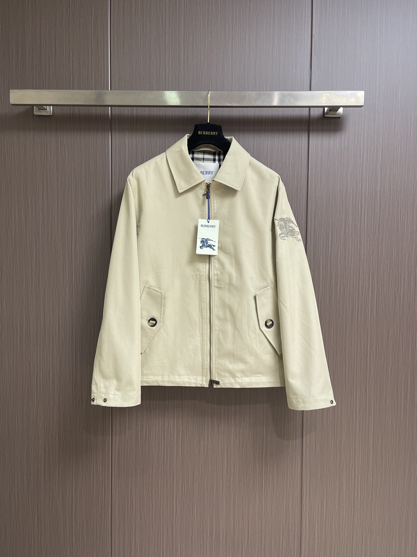 NO:904011,Burberry  Equestrian embroidered lapel jacket. The outer layer is made of high-density twill cotton fabric. The regular and tight diagonal weave makes the fabric have a solid structure and has excellent stiffness. The upper body is not easy to collapse and wrinkle, and can maintain a neat fit for a long time. High-density twill weave  The method can also additionally improve the windproof performance and can withstand the daily cool breeze. The interwoven yarn structure can disperse the friction stress, the fabric is wear-resistant and anti-wear, not easy to pilling and snagging, not easy to shrink and fade when washed, the texture is hard, the thickness is moderate and the drape is natural. The inner lining  It is a classic yarn-dyed plaid cotton lining. The inner and outer cotton materials say goodbye to the shortcomings of chemical fiber linings that are stuffy and stiff. It has a soft touch and is smooth to put on and take off without scratching the skin and not catching the inner layer. The plaid is interwoven with colored yarns and is not printed on the surface. It is not easy to fade after being washed for a long time.  Paste, the exposed details have exquisite texture. The professional Tajima multi-head computerized embroidery machine is used to operate synchronously, with multiple needle positions to route independently, and the embroidery is layered according to the plate making path. First, outline the fixed shape of the overall outer contour of the war horse, and then fill in the horse's muscles and flags in layers.  In the clothing texture area, fine short needles are stacked layer by layer to create a three-dimensional relief texture; the needle speed of the machine is uniform and stable, the needle pitch is even and uniform, and the thread routing is close to the twill texture of the fabric. Due to the addition of foam lining, it will not puncture the fibers and cause the fabric to bulge and damage. The simultaneous operation of multiple machine heads ensures standardized batch product processes, without jumps, missing stitches, and thread misalignment problems. The bartack reinforcement process, multiple stress points are all using professional bartack reinforcement technology, and the sewing machine is densely routed during sewing  Repeated circumferential stitching forms a tight and wear-resistant reinforced node, firmly locking the fabric at the corners of the bag, dispersing tensile stress and eliminating problems such as cracking of the bag, loosening of sutures, deformation and eversion of the fabric, etc. The stitch length is even and compact, and the routing is smooth and conforms to the fabric.  The texture will not irritate the skin, nor will it damage the crisp texture of the twill itself. After long-term repeated use and washing, the bag mouth remains stable and regular, and the solid and detailed workmanship combines practical protection with the texture of ready-made clothing. Sizes S-XL  Size S, shoulder width 50, bust 116, length 68.5, size M, shoulder width 51, bust 120, length 70, size L, shoulder width 52, bust 124, length 71.5, size XL, shoulder width 53, bust 128, length 73,,burberry,jackets & coats,19860909Burberry 马术绣花翻领外套,外层选用高密度斜纹纯棉面料,规整紧密的斜向织纹让布料结构扎实,自带优秀挺括度,上身不易软塌起皱,能长期保持利落版型.高密度斜纹织法还能额外提升防风性能,可抵挡日常凉风.纱线交织结构能分散摩擦受力,面料耐磨抗造,不易起球勾丝,水洗不易缩水褪色、质地发硬,厚度适中垂坠感自然.内里为经典色织格纹纯棉内衬,内外全棉材质告别化纤内衬闷肤生硬的缺点,触感柔和,穿脱顺滑不磨皮肤、不勾内搭.格纹以色纱交织成型,非表层印花,久洗不易掉色模糊,外露细节质感精致.采用专业田岛多头电脑绣花机同步作业,多针位独立走线,按照制版路径分层刺绣.先勾勒战马整体外轮廓固定形态,再分层填充马匹肌肉、旗帜、服饰纹理区域,细密短针层层堆叠塑造立体浮雕质感；机器走针匀速稳定,针距均匀统一,走线紧贴面料斜纹肌理,因加入泡沫衬,使其不会刺破纤维、不会造成布料起鼓破损,多机头同步运行保证批量产品工艺标准化,无跳线、漏针、走线错位问题.套结加固工艺,多处受力点位均采用专业套结加固工艺,缝制时缝纫机密集走线反复环绕缝合,形成紧实耐磨的加固结点,牢牢锁死袋口边角布料,分散拉扯应力,杜绝袋口开裂、缝线松脱、布料变形外翻等问题.针距均匀紧凑,走线平整贴合面料肌理,不会凸起硌肤,也不会破坏斜纹棉布本身的挺括质感.长期反复使用与水洗后,袋口依旧稳固规整,扎实的细微做工,让实用防护与成衣质感兼备.尺码S-XL  S码 肩宽50 胸围116 衣长68.5 M码肩宽51 胸围120 衣长70 L码 肩宽52 胸围124 衣长71.5 XL码 肩宽53 胸围128 衣长73,,burberry,jackets & coats,,Men's clothing