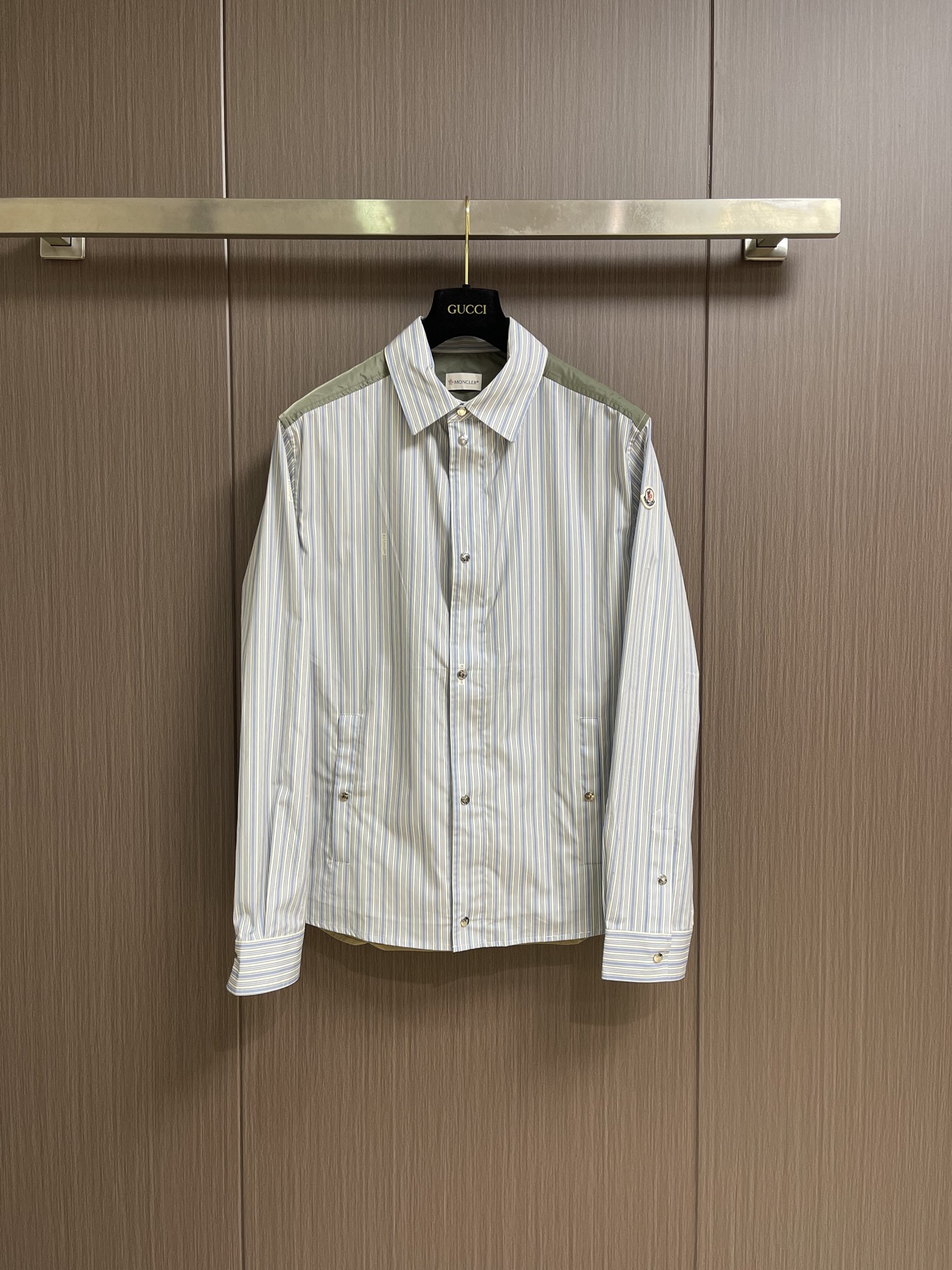 NO:914591,Moncler  2026SS new spring and summer striped patchwork shirt. The main body of the shirt is made of high-count yarn-dyed pure cotton poplin. The fine blue and white vertical stripes have a refreshing and attractive texture. The cloth surface is flat and wrinkle-resistant. The upper body is breathable, skin-friendly and not stuffy. The shoulders are made of military green nylon fabric with contrasting colors.  Splicing, a whole piece of khaki nylon interlining on the back, taking into account the stiff shape and light breathability, the transition stitching is neat and tight, the layered design is high-end and not monotonous. The details are full of recognition, the classic circular embroidered badge on the left arm is exquisite and three-dimensional but not cheap; door  The placket has a built-in brand-customized metal zipper, and the outer layer is equipped with a double-layered opening and closing with metal snap buttons with the same engraving. The snap button pockets on both sides take into account both storage and beauty. The double brand metal buttons on the cuffs can be freely adjusted for tightness. The loose slightly dropped shoulder version is not flattering on the figure, and can be worn alone.  It has a refreshing youthful feel, suitable for both inner and outer wear. It can be worn in spring, summer, early autumn, and can be used for commuting, traveling, and light business meetings. It has an Italian light luxury outdoor casual style. Mature men just need to wear a layered jacket when the season changes. Size 38-39-40-41  S-XL Size 38 bust 118 shoulder width 52 length 77 Size 39 bust 122 shoulder width 53 length 78 Size 40 bust 126 shoulder width 54 length 79 Size 41 bust 130 shoulder width 55 length 80,,jackets & coats,shirts,19860909Moncler 2026SS春夏新品条纹拼接衬衫,衣身主体甄选高支色织纯棉府绸,细密蓝白竖条纹肌理清爽耐看,布面平整抗皱,上身透气亲肤不闷汗；肩部采用军绿色尼龙面料撞色拼接,后背整片卡其锦纶衬布,兼顾挺括版型与轻薄透气性,过渡拼接走线工整严密,层次设计高级不单调.细节拉满辨识度,左臂经典圆形刺绣徽章,精致立体不廉价；门襟内置品牌定制金属拉链,外层搭配同刻字金属按扣双层开合,两侧按扣口袋兼顾收纳与美观,袖口双颗品牌金属纽扣可自由调节松紧.宽松微落肩版型不挑身材,单穿自带清爽少年感,内搭外搭都适配,春夏初秋三季可穿,通勤、出游、轻商务会面一件搞定,意式轻奢户外休闲风,成熟男士换季刚需叠穿神外套.尺码38-39-40-41 S-XL 38码胸围118 肩宽52衣长77 39码胸围122 肩宽53衣长78 40码胸围126 肩宽54衣长79 41码胸围130 肩宽55 衣长80,,jackets & coats,shirts,,Men's clothing