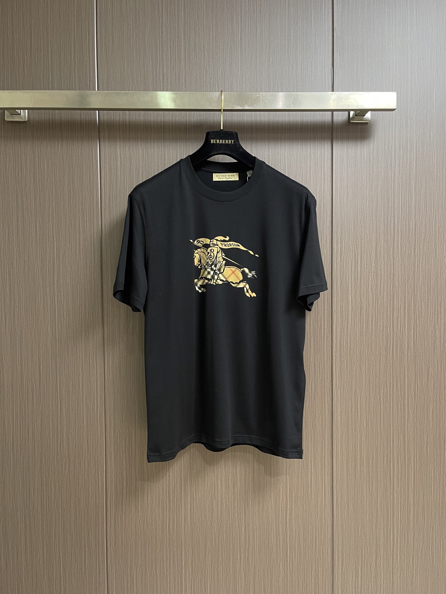 NO:950800,Burberry  Checkered war horse pattern cotton round neck short-sleeved T-shirt, this Burberry brand short-sleeved T-shirt is woven from high-quality pure cotton fabric. The texture is soft and delicate, breathable and skin-friendly, with good drape and stiffness. It is comfortable to wear and not easy to deform. The classic brand logo and war horse pattern on the chest are made with printing technology, and the pattern is three-dimensional and full, restoring the brand's iconic design.  Designed for texture. The round neck adopts reinforced hemming technology, and the stitching is smooth and neat, making it less likely to loosen after long-term wear; the cuffs and hem are finely stitched, and the workmanship is rigorous and elegant. The overall shape is loose and neat, the turning lines are even and smooth, and the details show the brand's craftsmanship, taking into account high-end texture and practicality for daily wear. The overall lines are straight and delicate, the fabric is comfortable and soft, and the colors are consistent and without color difference.  It can be matched with the same style to create a fashionable look, and can be used in various occasions. Customized accessories, complete with three standards, same style for men and women!  Size S-XXL,,burberry,T-shirt,tees,t-shirt,19860909Burberry 格纹战马图案棉质圆领短袖t恤,本款Burberry品牌短袖T恤,甄选高品质纯棉面料织造而成,质地柔软细腻、透气亲肤,兼具良好垂坠感与挺括度,穿着舒适且不易变形.胸前经典品牌标识与战马图案采用印花工艺打造,图案立体饱满,还原品牌标志性设计质感.圆领采用加固包边工艺,车线平整工整,久穿不易松垮；袖口与下摆采用精细锁边处理,做工严谨考究.整体版型宽松利落,车工走线均匀流畅,细节处尽显品牌匠心工艺,兼顾高级质感与日常穿搭实用性.整体走线平直细腻,面料舒适柔软,颜色一致无色差 能与同款搭配营造时尚造型,驾驭各种场合,定制辅料,三标齐全,男女同款！尺码S-XXL,,burberry,T-shirt,tees，t-shirt,,Men's clothing
