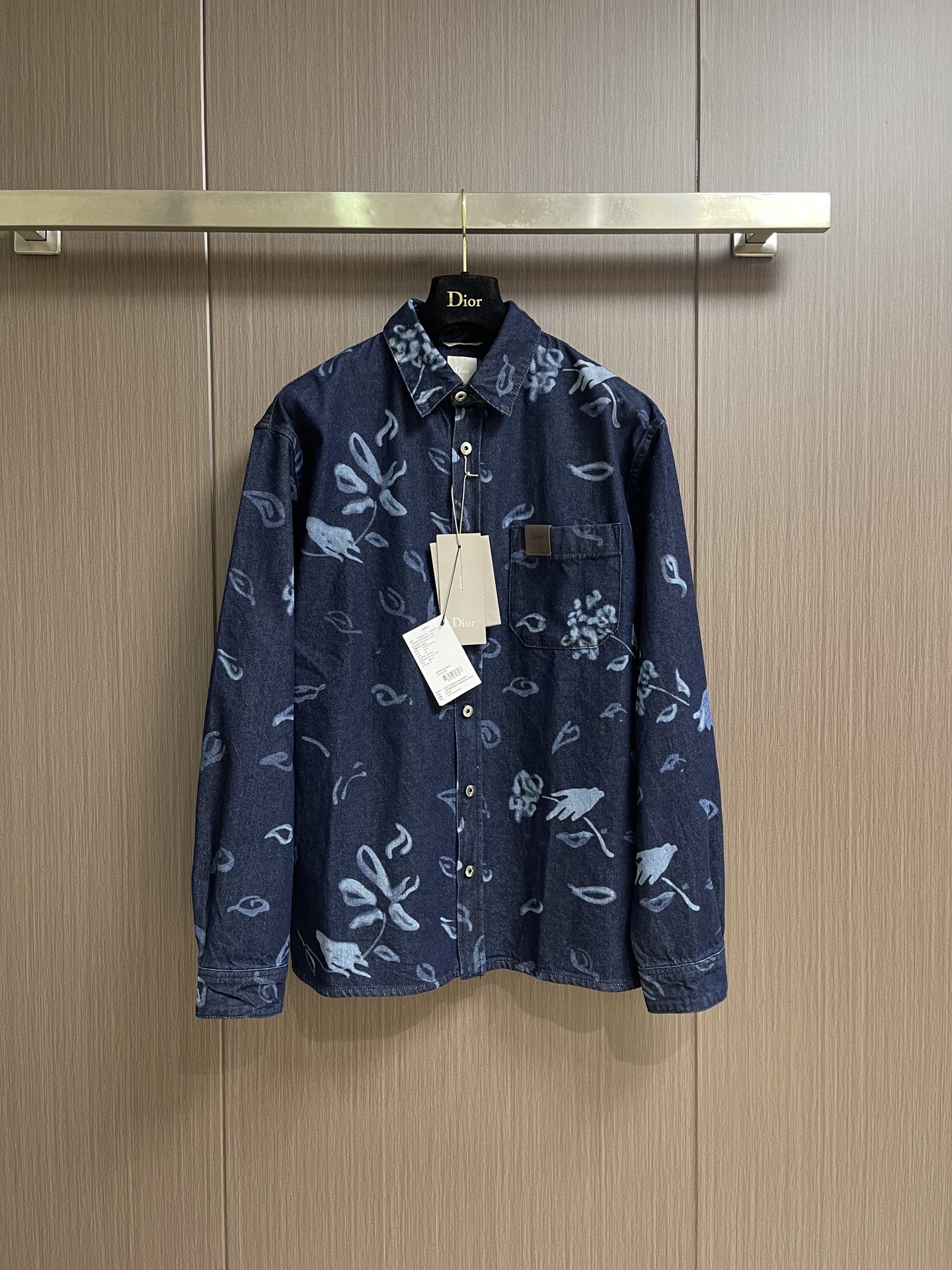 NO:928961,DIOR  The pocket letter leather brand floral burnt denim shirt is made of high-quality primary color denim fabric, which is thick and soft to the touch. It retains the classic texture of the denim material and is comfortable and stylish on the upper body. It is carefully made of blue cotton twill fabric, and the cotton content ensures breathability and durability. The fabric is processed by laser printing process to present  The floral patterns in artist Berard's works have a collision of dark and light blue levels, and are full of artistic atmosphere. From the iviera limited series, the light blue hand-painted floral print is laid out on the deep navy blue background. The random and freehand flowers and branches are scattered and distributed, blending art and fashion. It is loose  The dropped-shoulder silhouette is well-tailored and tolerant to the body shape, and the long-sleeved version is suitable for various seasons. The classic lapels are matched with front button closures, making it easy to put on and take off. It can be paired with the same floral denim shorts to create a striking high-end style. There are patch pockets on the chest with leather patches and metal button closures.  The fit is low-key and highlights the brand's texture. The cuff button design can be adjusted freely. The overall style is simple and elegant, and it is suitable for both inner and outer wear. The artistic print is combined with classic denim fabrics to break away from the constraints of stereotyped dressing and interpret the lazy and advanced dressing taste of contemporary men. Size 3738404244  Size 37, length 68, bust 120, shoulder width 48.5, size 38, length 70, bust 124, shoulder width 50, size 40, length 72, bust 128, shoulder width 51.5, size 42, length 74, bust 132, shoulder width 53, size 44.  Length 76, bust 136, shoulder width 54.5, dior, shorts, shirts,19860909DIOR 口袋字母皮牌花卉烧花牛仔衬衫,甄选优质原色牛仔面料,触感厚实柔软,保留牛仔材质经典肌理,上身舒适有型.采用蓝色棉质斜纹面料精心制作,棉成分确保透气与耐用性.面料经过激光印花工艺处理,呈现艺术家·贝拉尔作品中的花卉图案,深浅蓝色层次碰撞,艺术氛围感十足.来自iviera限定系列,深邃藏青底色之上铺陈浅蓝手绘风花卉印花,随性写意的花朵与枝叶错落分布,融合艺术与时尚气息.宽松落肩廓形剪裁得体,对身形包容度高,长袖版型适配多种季节.经典翻领搭配前排纽扣开合,穿脱简单便捷.可与同款花卉牛仔短裤成套搭配,打造醒目高订风格造型.胸前设置贴袋,搭配皮革补丁与金属纽扣开合,低调彰显品牌质感.袖口纽扣设计可自由调节.整体单穿简约大气,内搭外搭都十分适配.将艺术印花与经典牛仔面料融合,跳出刻板穿搭束缚,诠释当代男士慵懒高级的穿搭品味.尺码3738404244 37码 衣长68胸围120　肩宽48.5　 38码 衣长70胸围124　肩宽50　 40码 衣长72胸围128　肩宽51.5　 42码 衣长74　胸围132　肩宽53　　 44码 衣长76　胸围136　肩宽54.5,,dior,shorts,shirts,,Men's clothing