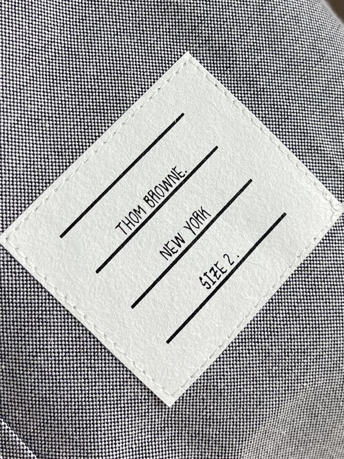 Thom browne TB袖筒纽扣调节袢（臂环）长袖衬衫，双袖的纽扣袢是该款最具辨识度的设计，既可以收