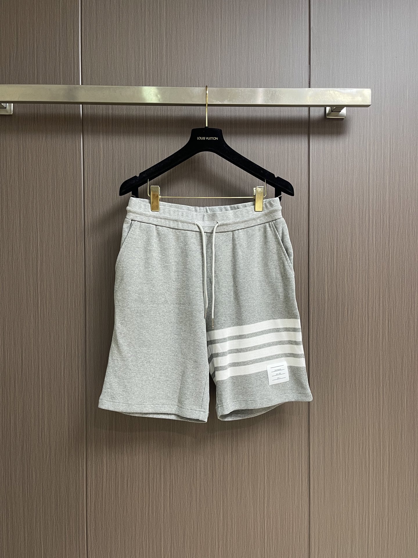 NO:935749,THOM BROWNE  Waffle shorts, these pitted four-bar casual shorts are made of high-density pitted knitted fabrics, using three-dimensional jacquard weaving technology. The texture is clear and full, soft and skin-friendly. It has the characteristics of breathability, perspiration, anti-wrinkle and stiffness, and is not easy to deform after long-term wear. The drawstring elastic waistband is matched with a metallic rope head, which is suitable for a variety of body shapes. It is easy to put on and take off and fits the waist and abdomen. Large pockets on both sides and back  The patch pockets are neatly made and the wiring is tight, which improves practicality and storage space. The four white bars on the trousers are made of integrated intarsia knitting technology, with neat and smooth lines, full and firm colors, and no risk of offset printing. The side brand white label and rear waist webbing details are low-key and highlight the recognition. The whole dress is loose and comfortable, with no restrictions on movement, suitable for daily life, sports and other scenes.  Size 1-2-3-4 Size 1 Waist 72 Hips 100 Front Wave 31 Pants Length 50 Size 2 Waist 76 Hips 104 Front Wave 32 Pants Length 52 Size 3 Waist 80 Hips 108 Front Wave 33 Pants Length 54 Size 4 Waist 84 Hips 112 Front Wave 34 Pants Length 56,,shorts,19860909THOM BROWNE 华夫格短裤,这款坑条四道杠休闲短裤甄选高密坑条针织面料,采用立体提花织造工艺,纹理清晰饱满,触感柔软亲肤,兼具透气排汗与抗皱挺括的特性,久穿不易变形.抽绳松紧腰头搭配金属质感绳头,适配多种身形,穿脱便捷且贴合腰腹.双侧大口袋与后贴袋做工工整,走线严密,提升实用性与收纳空间.裤身四道白杠采用一体嵌花针织工艺,线条工整流畅,色彩饱满牢固,无胶印脱落风险,侧边品牌白标与后腰织带细节,低调彰显辨识度.整件衣服版型宽松舒适,活动无束缚,适配日常、运动等多种场景. 尺码1码-2码-3码-4码 1码腰围72 臀围100 前浪31 裤长50 2码 腰围76 臀围104 前浪32 裤长52 3码 腰围80 臀围108 前浪33 裤长54 4码 腰围84 臀围112 前浪34 裤长56,,shorts,,Men's clothing