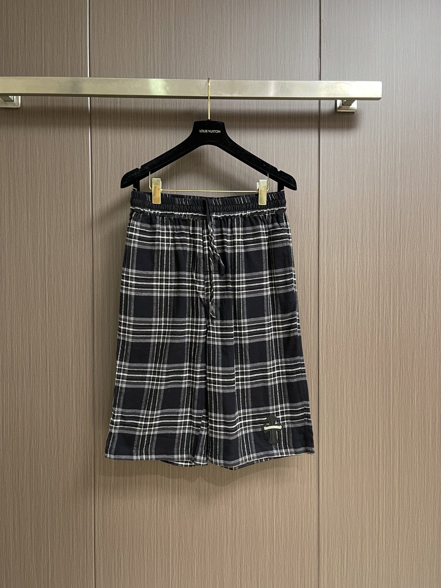 NO:935737,Chrome Hearts CH Chrome Hearts  Black and white plaid cross leather label wide-leg shorts, this black and gray plaid three-pointer is made of soft and smooth plaid woven fabric. The fabric texture is clear and regular, with good drape. It is skin-friendly, breathable and not easy to sweat. The waistband adopts widened and high-elastic elastic technology to adapt to a variety of waistlines. It is easy to put on and take off, and does not tighten the waist or slip. The overall loose straight cut, moderately expands the hip and leg space, allows free movement without tightness, and the trouser legs are rounded and hemmed.  Fine and smooth, not easy to get off-line and wear. The classic black and white plaid is printed and dyed firmly, and will not fade and turn white easily after repeated washing. The small and simple logo embellishment on the side of the pants enhances the overall sophistication. The seams of all pants are reinforced and overlocked, making the workmanship solid and durable. They are suitable for daily leisure and home travel. They can be matched and matched to create a retro and relaxed look. The overall wiring is straight and delicate, the fabric is comfortable and soft, and the colors are consistent without color difference.  Can be matched with the same style to create a fashionable look, to suit various occasions, customized accessories, complete with three standards!  Size S-M-L S ​​size waist 74 hips 106 pants length 60 M size waist 78 hips 110 pants length 61 L size waist 82 hips 114 pants length 62,,chrome hearts,chrome hearts,shorts,19860909Chrome Hearts CH克罗心 黑白格十字皮标阔腿短裤,这款黑灰格纹七分选用柔软顺滑的格纹梭织面料,织物纹理清晰规整,垂坠感佳,亲肤透气不易闷汗.腰头采用加宽高弹松紧工艺,适配多种腰围,穿脱无束缚,不勒腰不滑落.整体宽松直筒剪裁,适度扩容臀腿空间,活动自在无紧绷感,裤脚圆润包边走线细密平整,不易脱线磨损.经典黑白格纹印染牢固,反复水洗不易褪色发白,裤侧小巧简约标识点缀,提升整体精致度.全裤接缝均做加固锁边处理,做工扎实耐穿,日常休闲、居家出行都适配,搭配均可,随性打造复古松弛穿搭.整体走线平直细腻,面料舒适柔软,颜色一致无色差 能与同款搭配营造时尚造型,驾驭各种场合,定制辅料,三标齐全！尺码S-M-L S码 腰围74 臀围106 裤长60 M码腰围78 臀围110 裤长61 L码 腰围82 臀围114 裤长62,,chrome hearts,chrome hearts,shorts,,Men's clothing