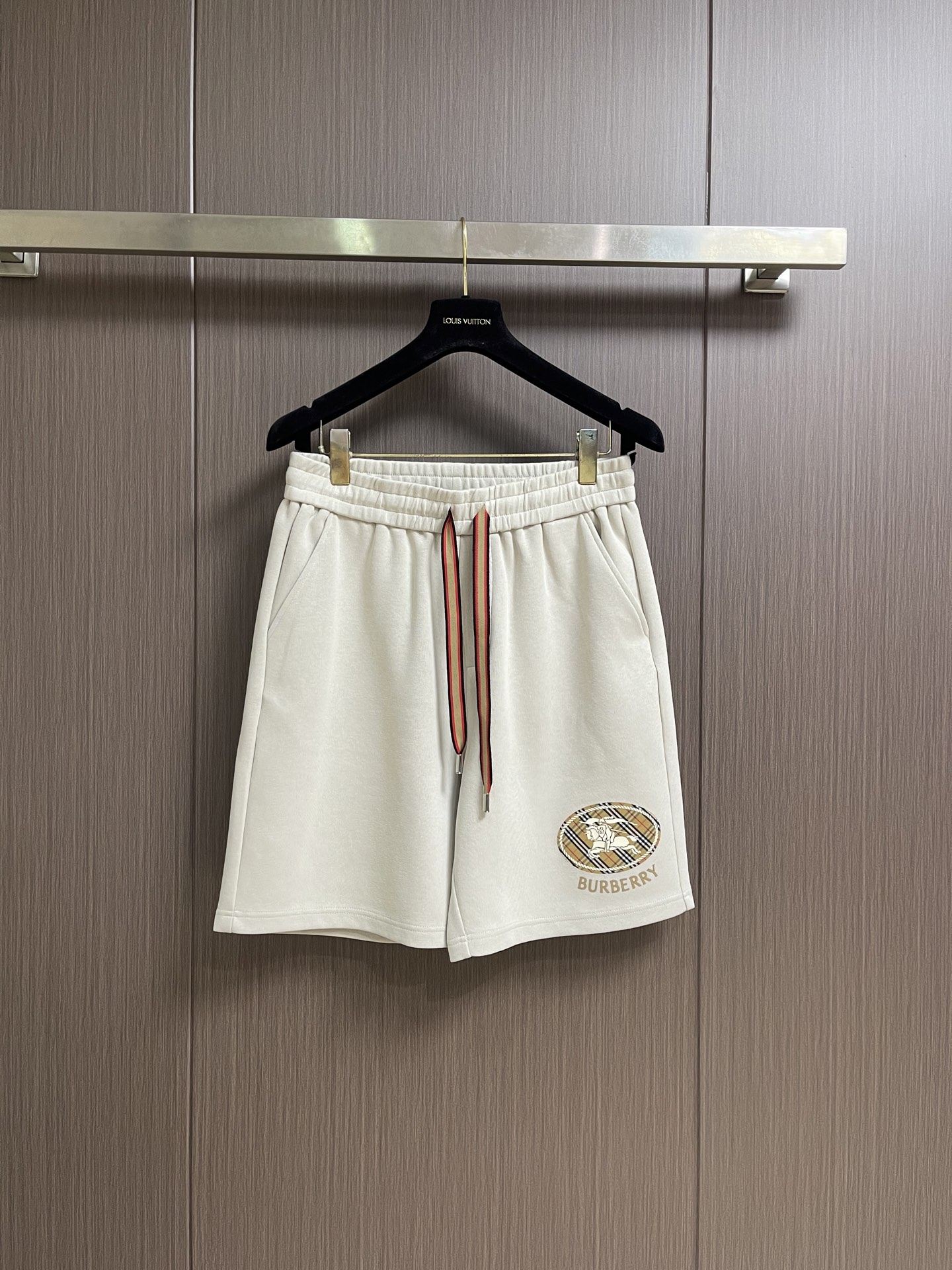NO:953593,Burberry  Cotton embroidered war horse logo pattern shorts are made of lightweight turned-over velvet cotton fabric, using cotton fiber as the main raw material. The front side has a smooth cotton surface, and the other side has been raised to form a fine velvet surface, which is breathable, hygroscopic and soft. The waist is designed with elastic bands and is matched with drawstrings.  The waist elastic band is stitched with elastic, and the line spacing is tight, making it stronger, smoother and more beautiful while also taking into account good elasticity. There are pockets on both sides, and the bag mouth is reinforced using the bartack process. The edge of the back patch pocket is sewn on the breech using an inlaid three-needle and four-thread process to enhance visual beauty and durability.  Size M-XXXL Size M Waist 72 Hips 70 Length 53 L Waist 76 Hips 72 Length 54 XL Waist 80 Hips 74 Length 55 XXL Waist 84 Hips 76 Length 5619860909Burberry 棉质刺绣战马徽标图案短裤,选用轻盈的翻面绒棉质面料,以棉纤维为主要原料,正面是光滑的棉质表面,另一面经过起绒处理,形成细腻的绒毛表面,具有透气性,吸湿性和柔软性.腰部采用松紧带设计,搭配抽绳调节,运用橡筋车缝合腰部松紧带,线距紧密,使其更加牢固、平整和美观同时兼顾良好的弹性.两侧设有口袋,运用套结工艺加固袋口.后贴袋边缘处运用嵌车三针四线工艺缝制于臀位之上,强化视觉美观度和耐用性. 尺码M-XXXL M码 腰围72 臀围70 裤长53 L码腰围76 臀围72 裤长54 XL码 腰围80 臀围74 裤长55 XXL码 腰围84 臀围76 裤长56 XXXL码腰围88 臀围78 裤长57,,burberry,shorts,,Men's clothing