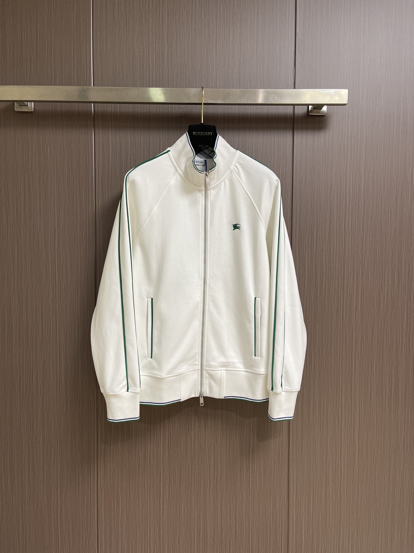 NO:946048,Burberry  Stand-up collar line tennis long-sleeve zipper jacket. This Burberry SS26 high-collar tennis sports jacket is made of high-count combed cotton knitted fabric, which has been softened and sanded. It has a delicate touch and skin-friendly feel, is breathable and sweat-wicking, is not easy to pill and harden after long-term wear, and has a crisp fit.  It is not easy to collapse and deform. The body is trimmed with retro green contrasting fine webbing. The lines are straight and symmetrical, and the segmentation is neat and exquisite. It has a classic tennis retro style. The war horse logo on the chest is made of fine three-dimensional embroidery technology. The stitches are dense and compact, and the outline is clear and full. Washed  It is not easy to fall off the thread. The inside of the stand-up collar is equipped with a classic plaid lining. The collar shape is firm and not easy to collapse. The central metal zipper is smooth and durable, and the pull is smooth and not stuck. The vertical pockets on both sides are sewn with reinforced edges, making the bag shape durable and stiff without deformation. The hem and cuffs are bumped.  Colored ribbed cuffs, rebound and stable fit to the body shape. The overall loose tailoring accommodates all body shapes, and the entire car is double-threaded with precision sewing, taking into account the texture of a light luxury brand, sports comfort and daily commuting wear attributes. The overall routing is straight and delicate, the fabric is comfortable and soft, and the colors are consistent without color difference.  Can be matched with the same style to create a fashionable look, to suit various occasions, customized accessories, complete with three standards!  Size S-XL Size S, length 66, shoulder width 53, chest 108, sleeve length 70, size M, length 68, shoulder width 54, chest 112, sleeve length 71, L length, length 70, shoulder width 55, chest 116, sleeve length 72,19860909Burberry 立领线条网球长袖拉链夹克外套,这款博柏利SS26高领网球运动夹克选用高支精梳棉质针织面料,经过柔化磨毛后整处理,触感细腻亲肤,透气排汗,长久穿着不易起球发硬,版型挺括不易软塌变形.衣身搭配复古绿色撞色细织带镶边,走线笔直对称,分割车工工整精致,经典网球运动复古格调.胸口战马标识采用精细立体刺绣工艺,针脚密实紧凑,轮廓清晰饱满,水洗不易脱线脱落.立领内侧搭载经典格纹内衬,领型定型牢固不易外翻塌陷,中央金属拉链顺滑耐久,拉动流畅不卡顿.两侧竖插袋做加固包边缝制,袋型持久挺括不变形,下摆与袖口采用撞色罗纹收口,回弹稳定贴合身形.整体宽松剪裁包容各类身形,全车双线精密缝制,兼顾轻奢品牌质感、运动舒适度与日常通勤穿搭属性.整体走线平直细腻,面料舒适柔软,颜色一致无色差 能与同款搭配营造时尚造型,驾驭各种场合,定制辅料,三标齐全！尺码S-XL S码 衣长66 肩宽53 胸围108 袖长70 M码 衣长68 肩宽54 胸围112 袖长71 L码衣长70 肩宽55 胸围116 袖长72 XL码 衣长72 肩宽56 胸围120 袖长73,,burberry,jackets & coats,jackets & coats,,Men's clothing