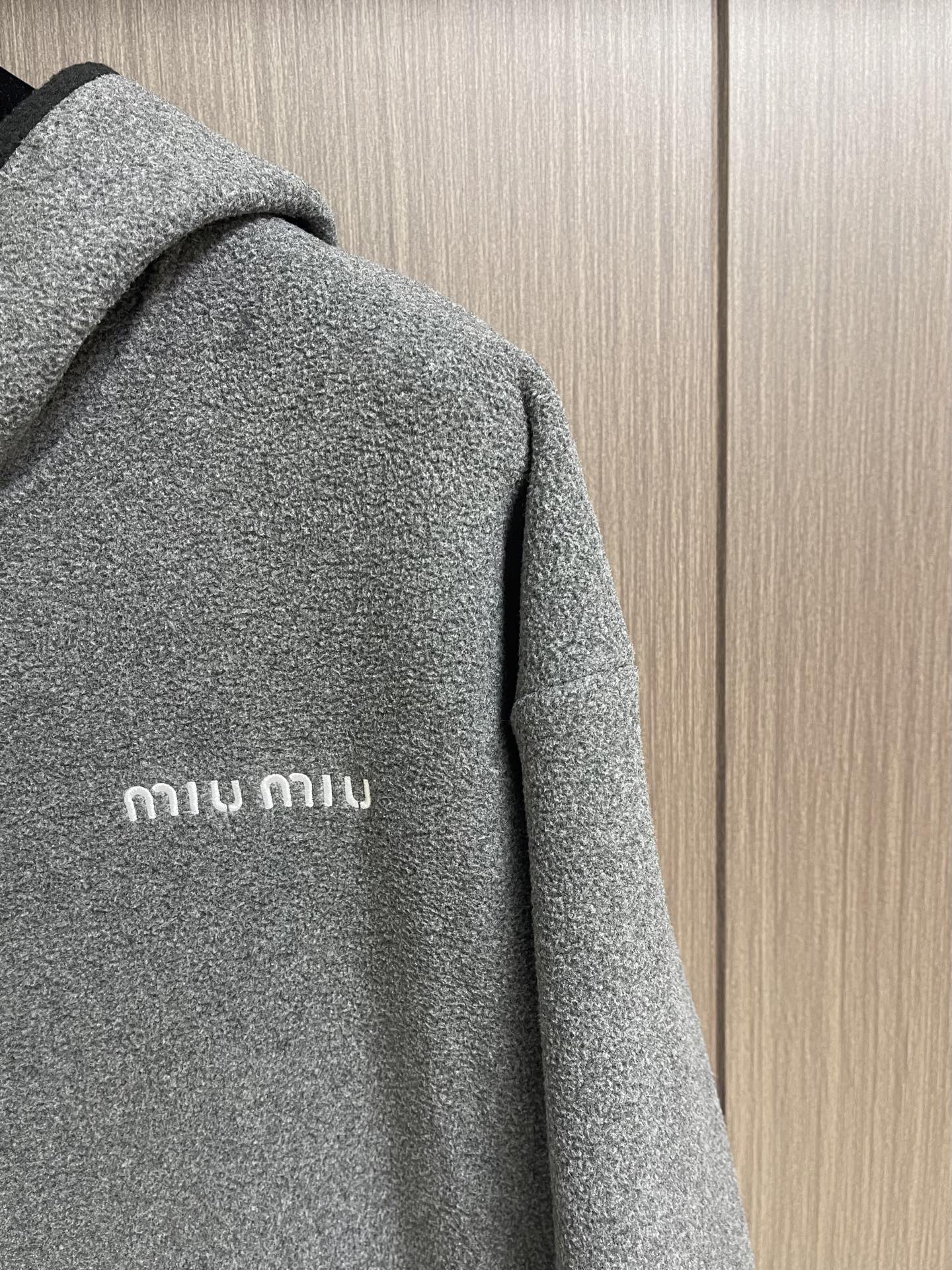 MIUMIU 抓绒拉链连帽外套，低调纹理铺陈全身，视觉层次丰富而不张扬。连帽立领设计，宽松直筒廓形，前开拉链利落有型；袖