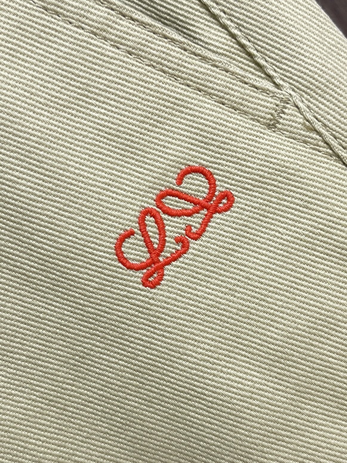 LOEWE 刺绣皮革长裤，定制暖沙精纺斜纹布，以燕麦柔米色作底，裤身右侧饰以红色刺绣，低调暗藏品牌基因，别致侧袋与锤环点