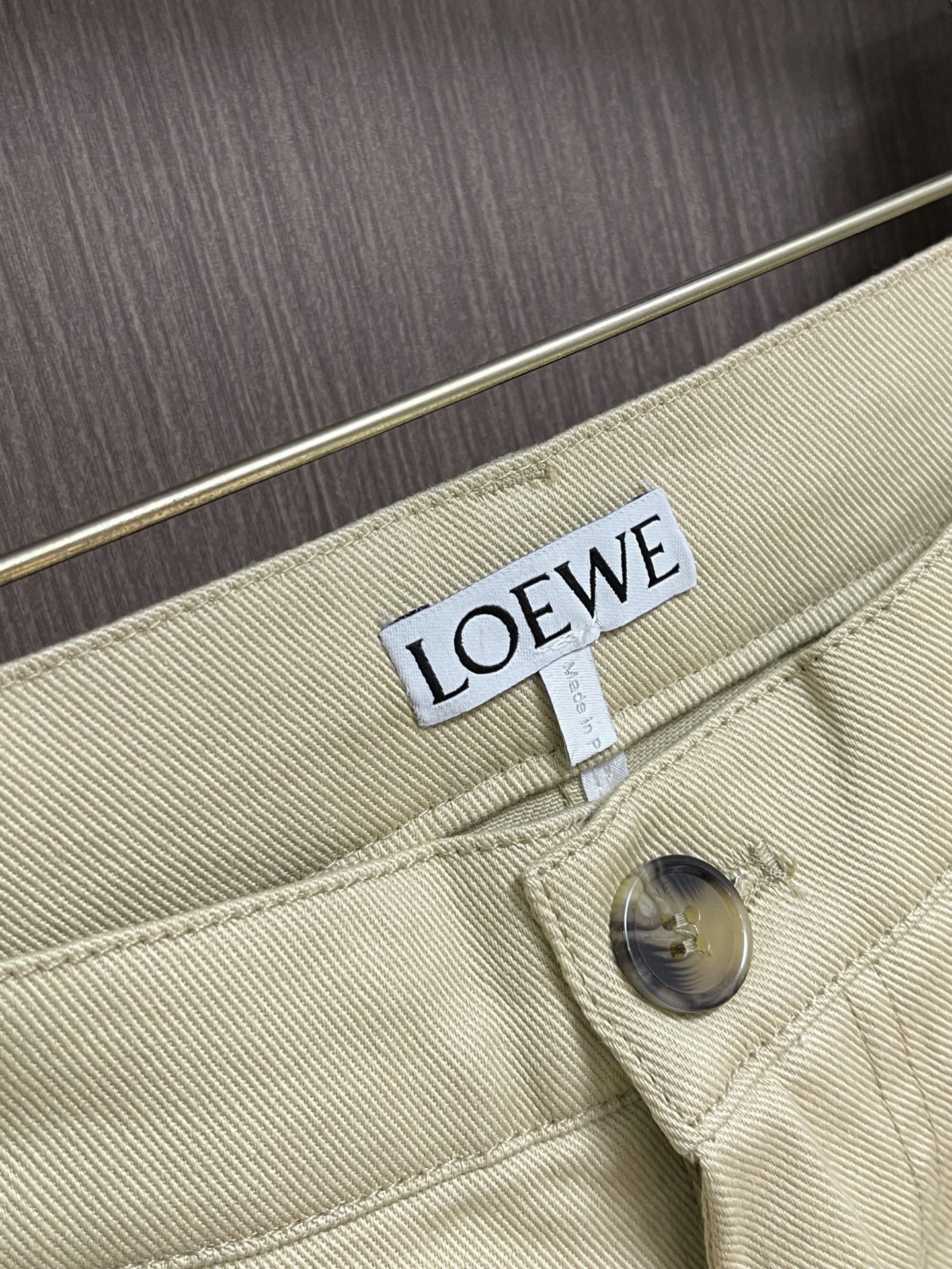 LOEWE 刺绣皮革长裤，定制暖沙精纺斜纹布，以燕麦柔米色作底，裤身右侧饰以红色刺绣，低调暗藏品牌基因，别致侧袋与锤环点
