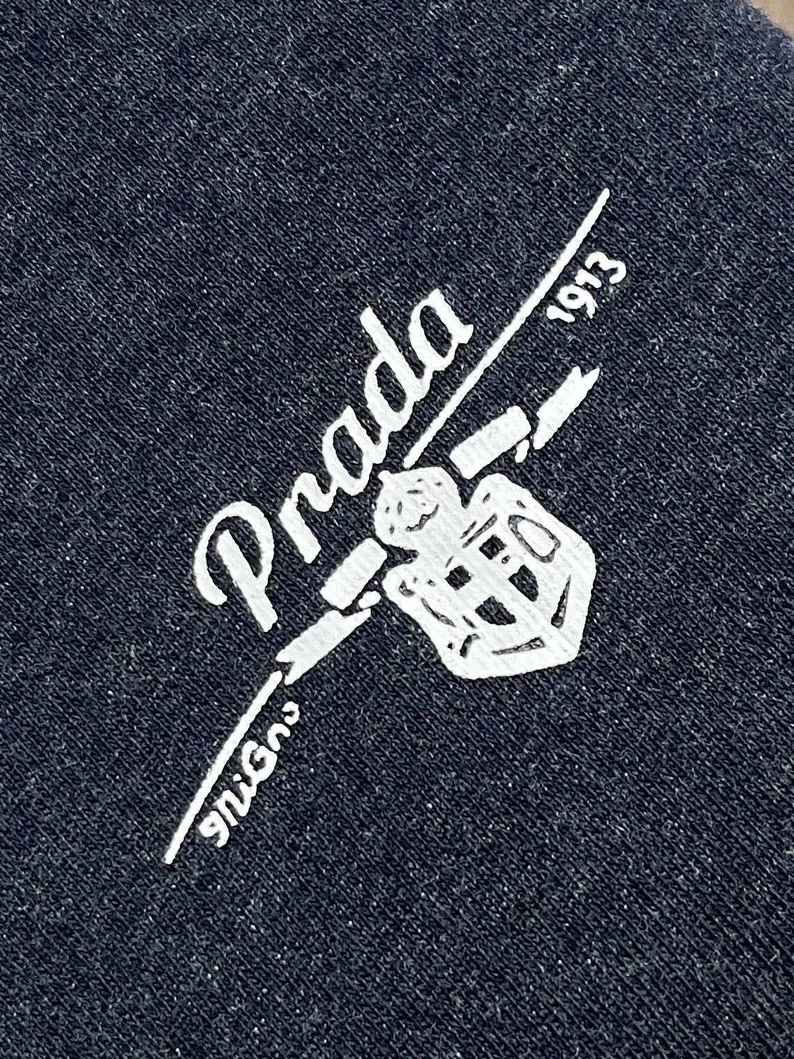 Prada 徽标条纹卫衣,定制夜靛云绒抓绒布,墨蓝藏青如暗夜凝萃,自带复古学院的柔光雅韵,领口与袖口缀以酒红与蓝白撞色罗 Prada 徽标条纹卫衣,定制夜靛云绒抓绒布,墨蓝藏青如暗夜凝萃,自带复古学院的柔光雅韵,领口与袖口缀以酒红与蓝白撞色罗