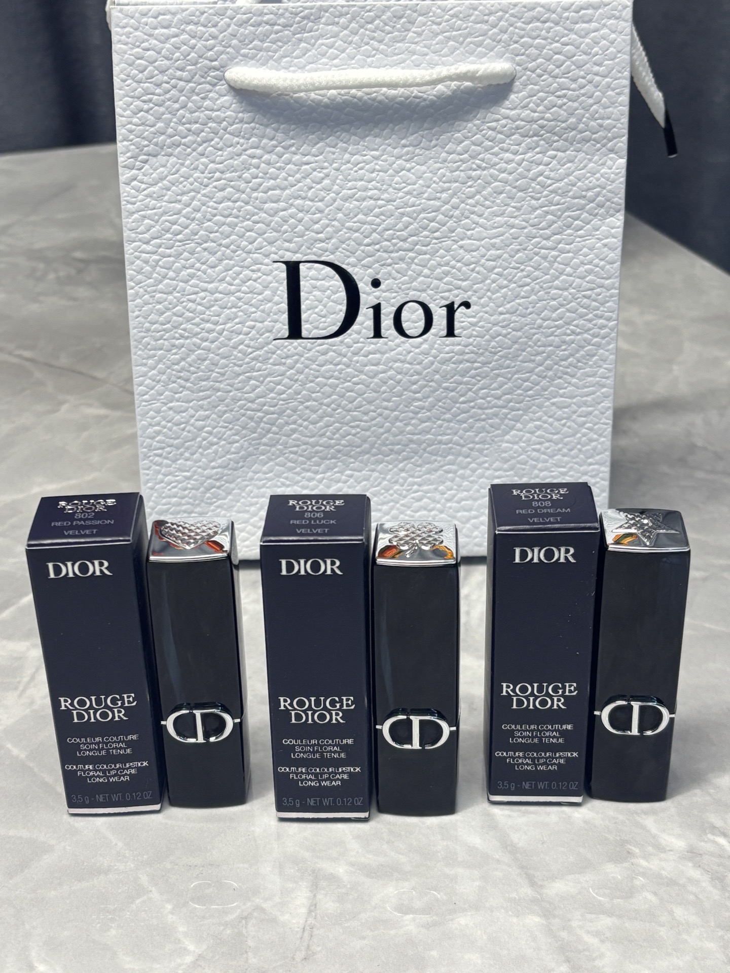 发225💰单支 （需配礼盒包装🎁➕10 ） 
⭕️ꫛꫀꪝ ❥&mdash;&mdash;❤上新➡️专柜品质【官方新品@邓为@代言&middot;Dior迪奥烈艳蓝金磁吸盖开运红限定正装口红唇膏#802/#808/#806】
🎁配专柜手提袋 🛍 
全新迪奥来袭💥美到心里去～
迪奥新年新出的开运红限定版，迪奥就是调色大师吧，简直就是把迪奥的幸运美学焊在唇膏上，谁涂谁是被幸运眷顾的时髦精～简直美到犯规~新年涂很对味！
膏体雕花灵感来自幸运星，寓意美好，磁吸外壳开合顺手，细节满分！非常吸睛！送闺蜜👭女友💞老婆😘妈妈👩 绝对会爱不释手👄

现货颜色：#802/#808/#806 色号下单备注

🌟迪奥烈艳蓝金开运限定口红💄#802桃花红
谁能拒绝这支带着满满爱意的口红呢？丝绒质地的暖调红，暖调红粉调也太甜了吧！上嘴是那种嫩嫩的蜜桃红茶感，丝绒妆效却润嘟嘟的，完全不会卡纹显唇纹。像把恋爱的甜都融在唇间~ 灵感源自迪奥先生的爱心护身符，涂上它，仿佛连空气都变得浪漫起来，约会时涂这支，桃花运不得蹭蹭涨？
日常涂这支超温柔，上班约会都合适，涂完感觉自己像自带柔光滤镜，男朋友都夸我气色好到发光！
	
🌟迪奥烈艳蓝金开运限定口红💄#806 招财红
带着复古感的番茄色，丝绒质地巨丝滑，上嘴轻轻一抹就显色，完全不用反复叠加。和秋冬的氛围感很搭，黄皮的好搭子。素颜薄涂秒提气色，厚涂配个大衣，气场直接拉满！而且它一点不拔干，含的护唇成分让嘴唇一整天都软软的，喝水也不容易沾杯，持久度绝了！

🌟迪奥烈艳蓝金开运限定口红💄#808锦鲤红
这个也是绝绝子！真的好爱～冷调红调里藏着星光细闪，是那种&ldquo;我要去追梦&rdquo;的底气色~ 灵感来自迪奥的幸运星传说，涂上它，感觉连追梦的路都被幸运铺满，丝绒质地超显色，薄涂提气色，厚涂气场全开✨ 很有活力的颜色，能涂出温柔灵动感，很显气色，而且黄皮也能驾驭哦，橄榄皮的姐妹涂着会更加显白！不拔干，持久度优秀，新年聚会必备，开年好运感拉满🎉。日常涂也很绝！新年涂这个真的会幸运一整年吧！！

