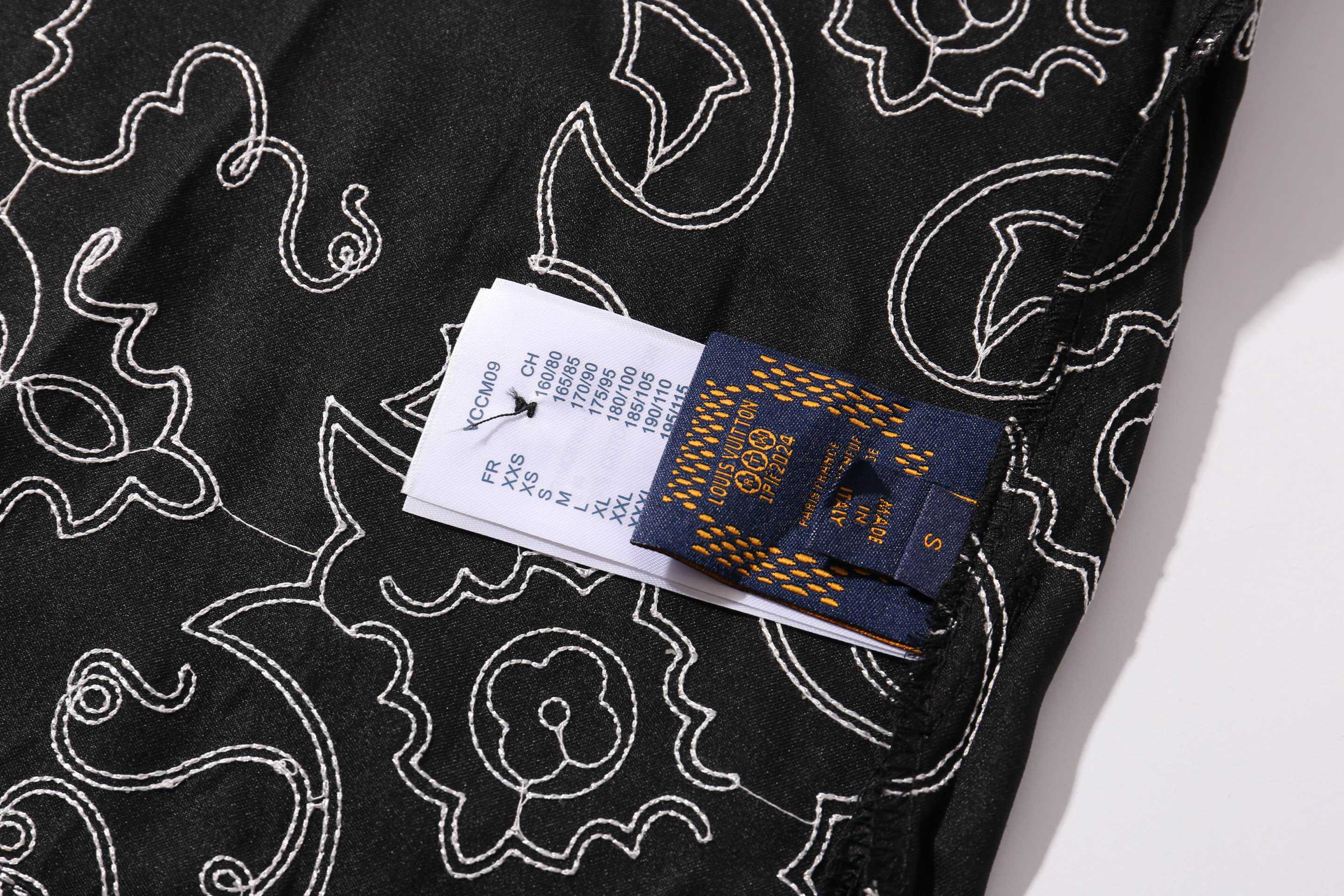 高品上新 Louis Vuitton/路易威登 蔓藤靴线绣花刺绣短袖衬衫 原版14,600购入开发,添柏岚联名系列.定制原版100%桑蚕丝面料,采用了刺绣花纹缝线,米粒满幅刺绣工艺其特点在于通过精细的绣制手法,在整幅绣品上均匀而密集地绣制出类似米粒大小的图案或纹样,以达到满幅覆盖、精致细腻的视觉效果.刺绣时针脚和绣线的运用形成类似米粒的细小单元,这些单元紧密排列,构成整体的纹样,工艺相当的复杂,给人一种艺术感十足的视觉.