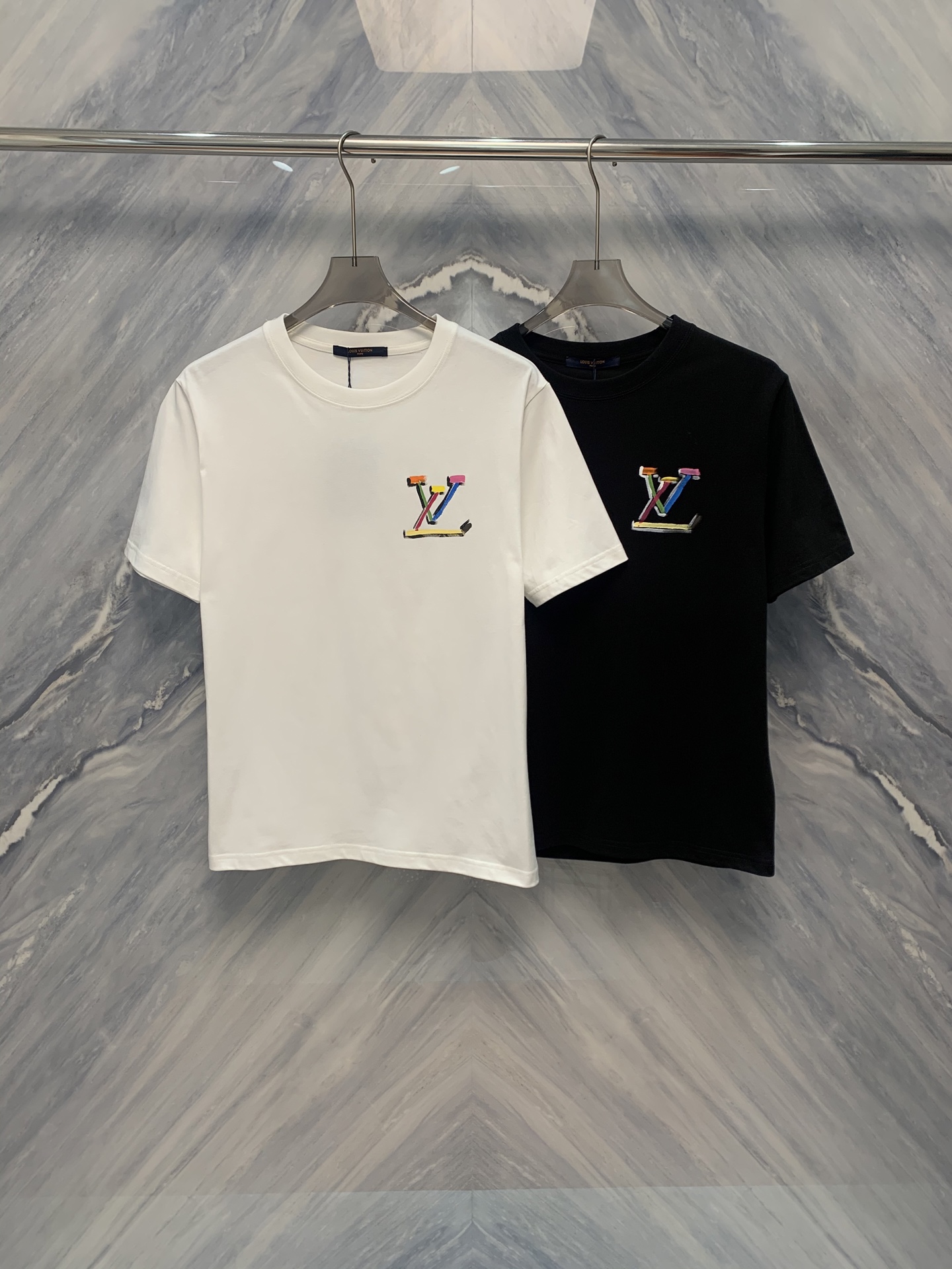 NO:419354,25 spring and summer new 1V floral graffiti cotton round neck short-sleeved T-shirt combines fashion and comfort. It uses high-quality cotton material, soft and breathable. Classic round neck design is simple and versatile. The feature is that the whole body is floral graffiti pattern, colorful and full of artistic atmosphere, showing the personality. The pattern and the brand's classic Monogram elements are cleverly integrated to show the brand's unique charm. The cuffs and hem are exquisite ribbed, durable and comfortable. Whether it is matched with casual pants or jeans, it can easily show a fashionable attitude. Suitable for spring and summer wear, it is an ideal choice for daily life and travel. In terms of care, it is recommended to wash gently to keep the original texture and beauty of the clothes, and extend the life of the wear. This T-shirt is not only a fashionable item, but also a work of art, adding highlights to you who pursue a quality life. Wear it and enjoy the dual experience of comfort and fashion, which is an ideal choice for every young person who pursues a quality life. Color: Black  White Size: S-2XL S: Bust 100 Length 69 Shoulder width 44 Sleeve length 22 M: Bust 104 Length 70 Shoulder width 45 Sleeve length 23 L: Bust 108 Length 71 Shoulder width 46 Sleeve length 24 XL: Bust 112 Length 72 Shoulder width 47 Sleeve length 25 XXL: Bust 116 Length 73 Shoulder width 48 Sleeve length 26, jeans, T-shirt,tees, t-shirt,alexander wang1986090925春夏新品1V花卉涂鸦棉质圆领短袖T恤集时尚与舒适于一体.采用优质棉料,柔软透气.经典圆领设计,简约百搭.特色在于全身花卉涂鸦图案,色彩斑斓,充满艺术气息,彰显个性.图案与品牌经典Monogram元素巧妙融合,展现品牌独特魅力.袖口及下摆精致罗纹,耐穿且舒适. 无论是搭配休闲裤还是牛仔裤,都能轻松展现时尚态度.适合春夏穿着,是日常与旅行的理想选择.护理上,建议轻柔手洗,保持衣物原有质感与美观,延长穿着寿命.这款T恤不仅是时尚单品,更是艺术品,为追求品质生活的您增添亮点.穿上它,享受舒适与时尚的双重体验,是每一个追求品质生活的年轻人的理想选择. 颜色:黑色 白色 尺寸:S-2XL S :胸围100 衣长69 肩宽44 袖长22  M :胸围104 衣长70 肩宽45 袖长23  L :胸围108 衣长71 肩宽46 袖长24  XL :胸围112 衣长72 肩宽47 袖长25  XXL :胸围116 衣长73 肩宽48 袖长26,,jeans,T-shirt,tees，t-shirt,alexander wang,Men's clothing