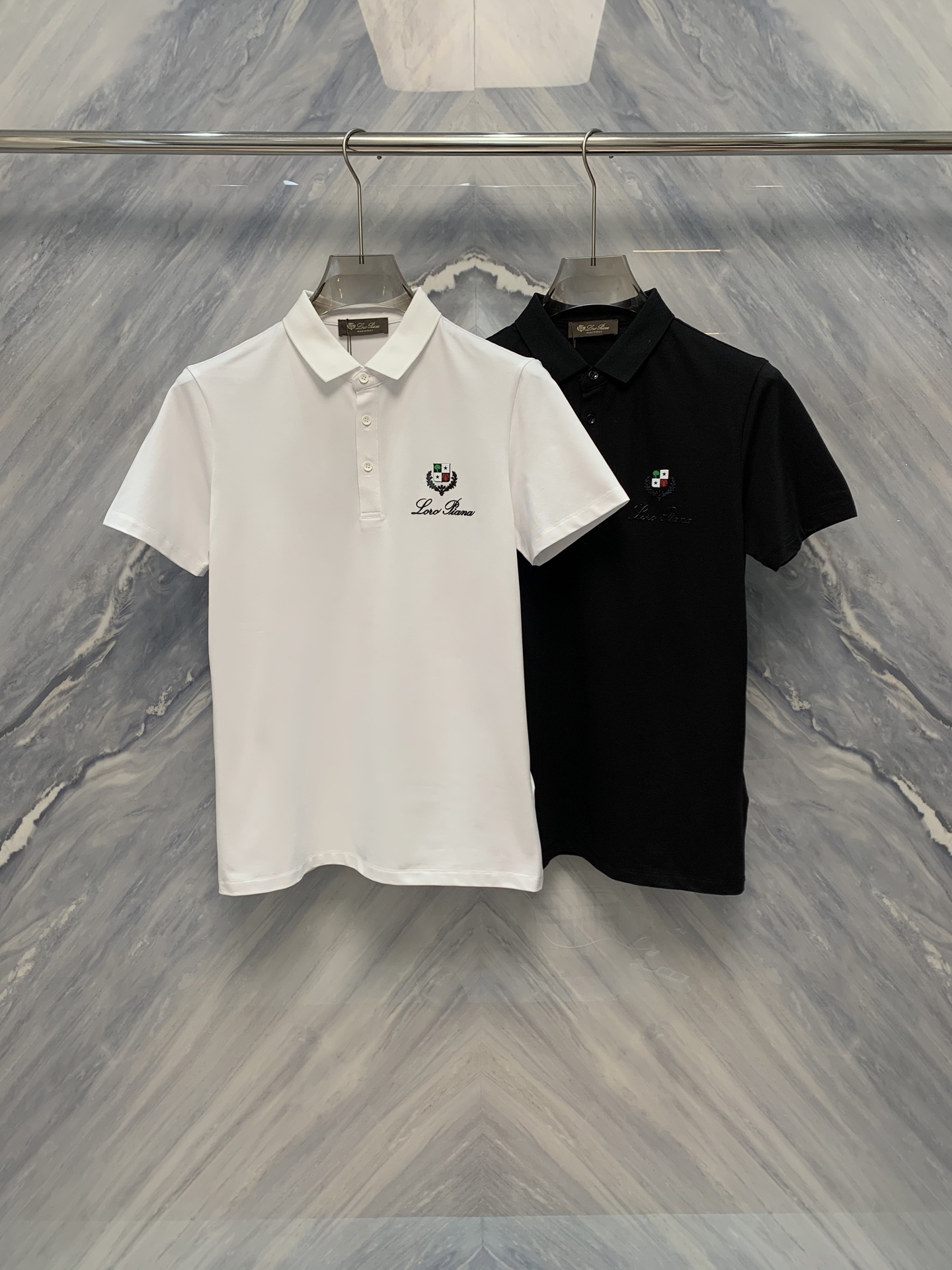 NO:500493,25 spring and summer new OEM factory order Lao Qianfeng LP mercerated bead floor fabric lapel embroidered logo Polo shirt, perfectly blending classic design with luxurious texture, is an indispensable boutique in your wardrobe. The shirt body adopts a unique blend proportion and combined with exquisite merceration processing technology to make the surface of the fabric appear delicate luster, soft and excellent breathability, ensuring that it can be kept refreshing and comfortable in the hot summer.  The classic lapel design is not only elegant and durable, but also fits the neckline and shows the wearer's spirit. Each of the fine buttons on the neckline and cuffs has been carefully selected and customized, and the details show the brand's persistent pursuit of quality. The embroidered logo on the left chest is the finishing touch of the entire Polo shirt. The exquisite patterns and delicate stitches show the brand's excellent craftsmanship. The colors and fabrics are harmoniously integrated, which not only demonstrate the brand's identity, but also low-key luxury. Color: Black White Size: M-3XL M: Bust 98 Length 68 Length 42 Length 20 Length 102 Length 69 Length 43 Length 21 XL: Bust 106 Length 70 Length 44 Length 22 XXL: Bust 110 Length 71 Length 45 Length  Sleeve length 23 3XL: bust 114 garment length 72 shoulder width 46 sleeve length 24, loro piana, alexander wang1986090925春夏新品代工厂订单老钱风LP丝光珠地面料翻领刺绣logo Polo衫,将经典设计与奢华质感完美融合,是您衣橱中不可或缺的精品.衫身采用独特混纺比例,结合精湛的丝光处理技术,使面料表面呈现出细腻的光泽,触感柔软且具有极佳的透气性,确保在炎炎夏日中也能保持清爽舒适. 经典的翻领设计不仅优雅耐看,更贴合颈部线条,展现穿着者的精神风貌.领口与袖口的精细纽扣,每一颗都经过精心挑选与定制,细节之处尽显品牌对品质的执着追求.而位于左胸的刺绣logo,则是整件Polo衫的点睛之笔,精致的图案与细腻的针脚彰显着品牌的卓越工艺,色彩与面料和谐相融,既彰显品牌身份,又不失低调奢华. 颜色:黑色 白色 尺寸:M-3XL M: 胸围98 衣长68 肩宽42 袖长20  L: 胸围102 衣长69 肩宽43 袖长21  XL: 胸围106 衣长70 肩宽44 袖长22  XXL: 胸围110 衣长71 肩宽45 袖长23  3XL: 胸围114 衣长72 肩宽46 袖长24,,loro piana,alexander wang,Men's clothing