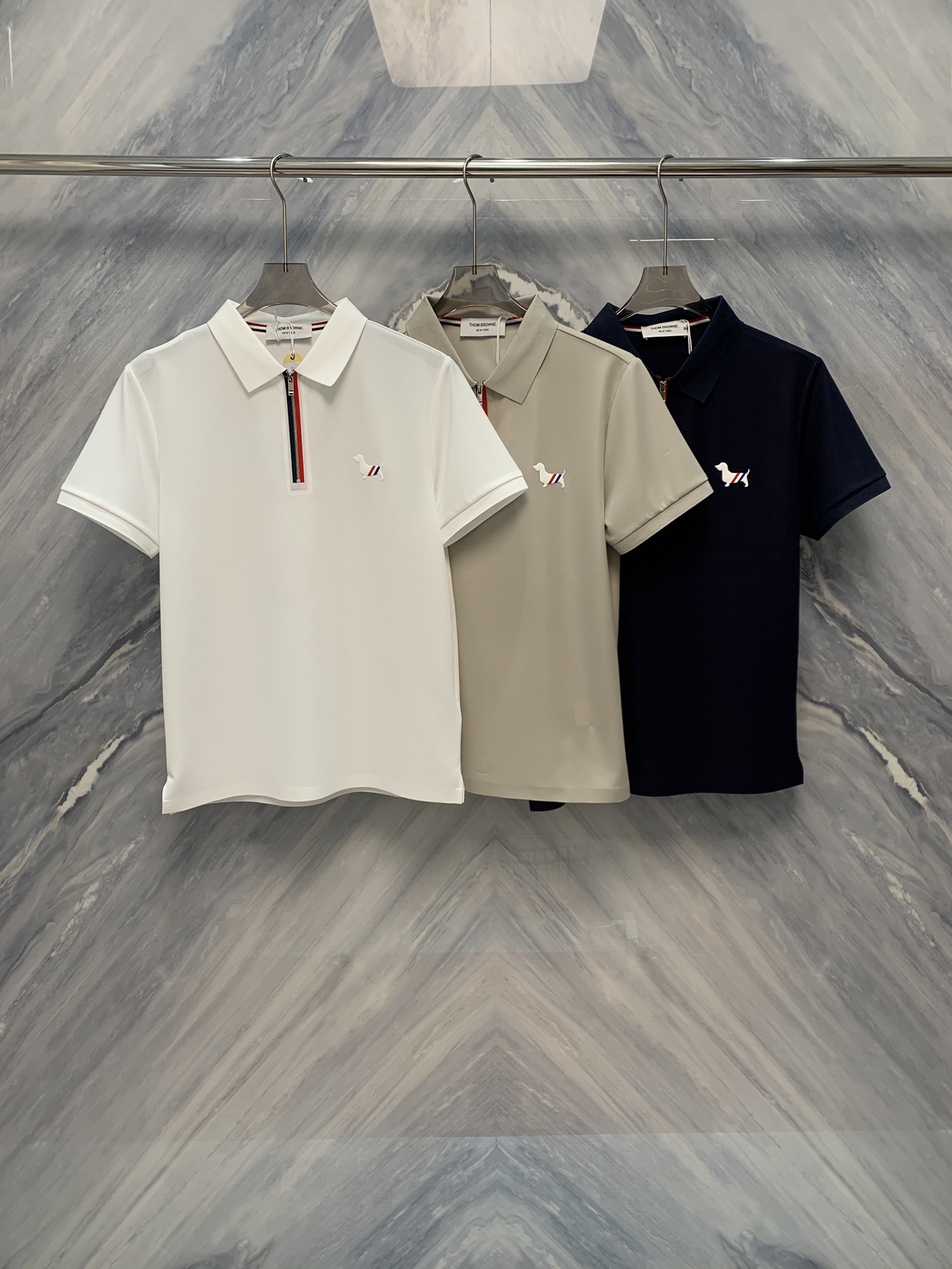 NO:500489,The new TB mercerated cotton lapel puppy embroidered zippered Polo shirt with exquisite details and unique design shows extraordinary quality and charm. It uses high-quality mercerated cotton fabric, which has special treatment to make the surface of the fabric smooth and soft, with silky luster, comfortable and skin-friendly. At the same time, the fabric has good breathability and moisture absorption, which is suitable for wearing in various occasions. The classic lapel design is simple and generous, showing a capable temperament. The neckline adopts exquisite edge wrapping technology, which is not easy to deform and durable. The puppy embroidery embroidery on the chest is lifelike, adding a touch of playfulness and vitality to the whole dress. The embroidery process is exquisite and smooth, showing high-quality details. The zipper design is unique, making it easy to put on and take off. The zipper head has a unique shape, adding a sense of fashion to the clothes. It fits the body and is not easy to deform. Color: White Khaki  Navy Blue Size: M-3XL M: Bust 100 Length 67 Shoulder width 43 Sleeve length 21 L: Bust 104 Length 68 Shoulder width 44 Sleeve length 22 XL: Bust 108 Length 69 Shoulder width 45 Sleeve length 23 XXL: Bust 112 Length 70 Shoulder width 46 Sleeve length 24 3XL: Bust 116 Length 71 Shoulder width 47 Sleeve length 25,,alexander wang1986090925春夏新品TB丝光棉翻领小狗刺绣点缀拉链设计Polo衫,以其精致的细节和独特的设计,展现出不凡的品质与魅力.采用优质丝光棉面料,经过特殊处理,使面料表面光滑柔软,具有丝绸般的光泽,舒适亲肤.同时,面料的透气性和吸湿性良好,适合各种场合穿着. 经典的翻领设计,简洁大方,展现出干练的气质.领口采用精致的包边工艺,不易变形,经久耐用.胸前的小狗刺绣点缀,栩栩如生,为整件衣服增添了一抹俏皮和活力.刺绣工艺精细,线条流畅,展现出高品质的细节处理.拉链设计独特,方便穿脱.拉链头的造型别致,增添了衣服的时尚感.贴合身形,不易变形. 颜色:白色 卡其色 藏青色 尺寸:M-3XL M:胸围100 衣长67 肩宽43 袖长21  L:胸围104 衣长68 肩宽44 袖长22  XL:胸围108 衣长69 肩宽45 袖长23  XXL:胸围112 衣长70 肩宽46 袖长24  3XL:胸围116 衣长71 肩宽47 袖长25,,alexander wang,Men's clothing