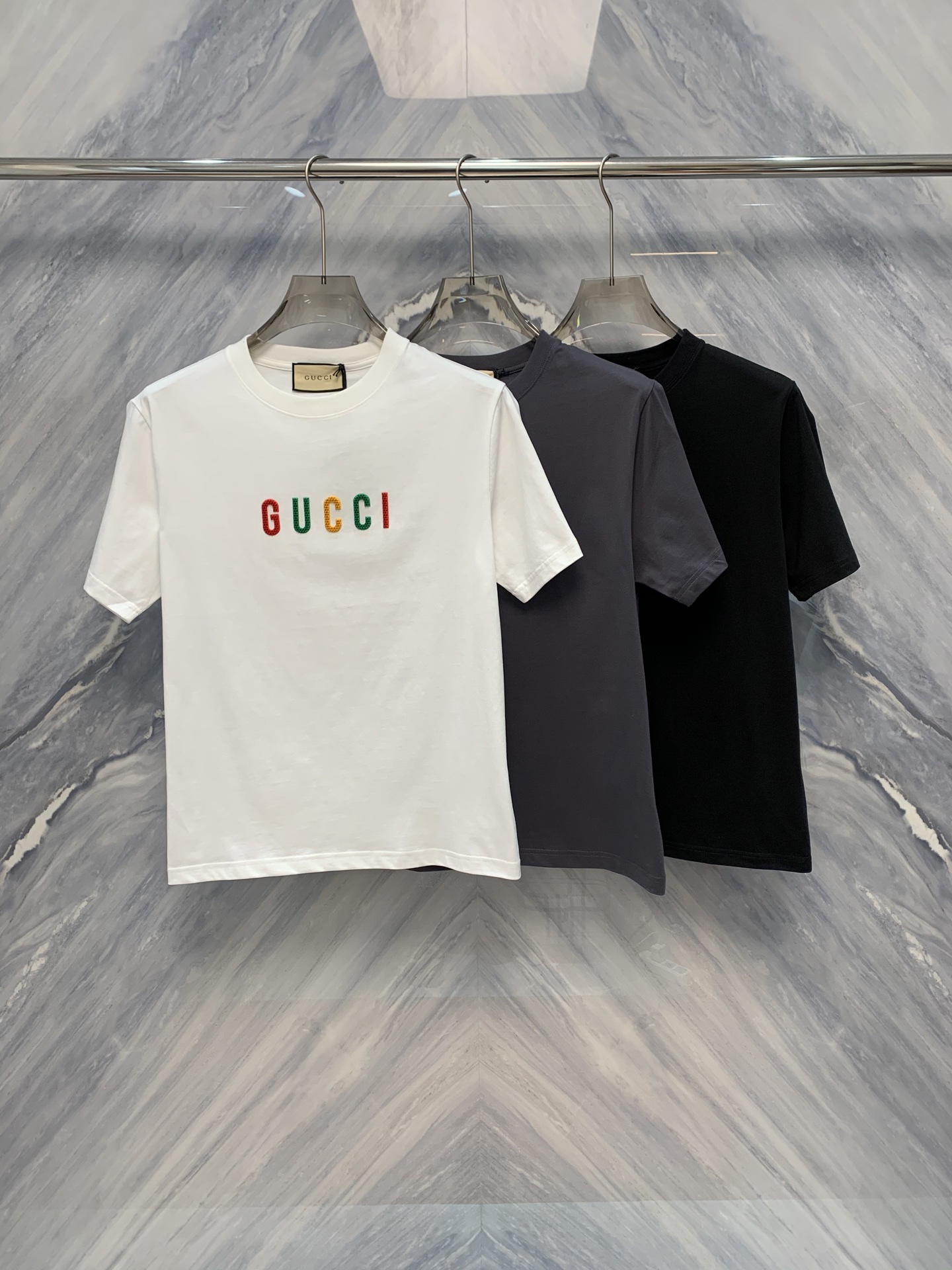 NO:419290,The new round-neck cotton short-sleeved design of the 25 spring and summer G home rubber logo has become a favorite in the fashion industry with its exquisite details and comfortable wearing experience. First of all, the short-sleeved sleeves are made of pure cotton, soft and breathable, suitable for wearing in all occasions. Secondly, the classic round-neck design is simple and generous, and can well modify the neck lines. Whether it is matched with jeans or casual pants, it can be easily controlled. The iconic G home rubber logo is printed in front of the short-sleeved sleeves. The logo is made of special rubber material, which has a three-dimensional and is not easy to fall off. Whether it is machine-washed or hand-washed, it can be kept intact. This design not only enhances the overall texture of the clothes, but also highlights the wearer's taste and identity. In addition, the cuffs and hem of the clothes are threaded with double needles, and the details are handled in place, making the clothes more durable and not easily deformed. Color: White Black Gray  Size: S-2XL, gucci, jeans, T-shirt, alexander wang1986090925春夏新品G家橡胶logo设计的圆领棉质短袖,凭借其精致的细节和舒适的穿着体验,成为了时尚界的宠儿.首先,短袖采用纯棉材质,柔软透气,适合各种场合穿着.其次,经典的圆领设计,简洁大方,能够很好地修饰颈部线条.无论是搭配牛仔裤还是休闲裤,都能轻松驾驭. 短袖的正前方印有G家标志性橡胶logo,logo采用特殊的橡胶材质,具有立体感且不易脱落,无论是机洗还是手洗都能保持完好无损.这一设计不仅提升了衣服的整体质感,还彰显了穿着者的品味和身份.此外,衣服的袖口和下摆均采用双针走线,细节处理非常到位,使得衣服更加耐穿,不易变形. 颜色:白色 黑色 灰色 尺寸:S-2XL,,gucci,jeans,T-shirt,alexander wang,Men's clothing