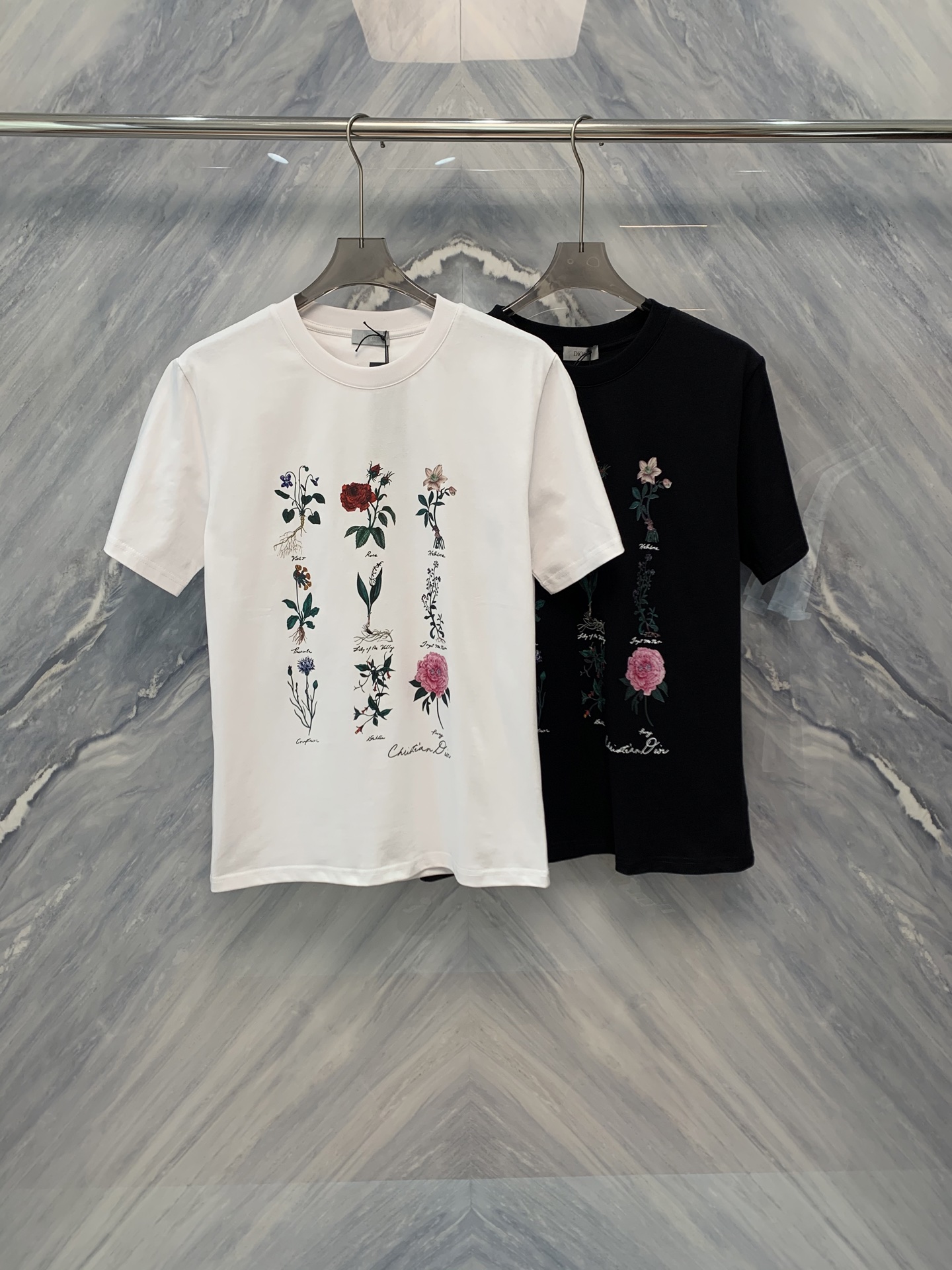 NO:419376,The new 25-spring and summer CD art floral printed round neck cotton short-sleeved T-shirt is a must-have item in summer wardrobe. The T-shirt is made of cotton, soft and breathable, skin-friendly and comfortable, and is suitable for wearing of all skin types. The cotton fabric not only has strong sweat absorption, but also maintains the shape of the clothes and is not easy to deform. The classic round neck design is simple and elegant, suitable for wearing in all occasions. The slim tailoring shows the wearer's figure advantages while not losing comfort.  The artistic floral prints on the T-shirt adopt advanced digital printing technology, with clear patterns and bright colors. The floral pattern design is full of artistic sense, adding a bit of romance and vitality to the T-shirt. The neckline, cuffs and hem of the T-shirt are all made of double-needle thread to reinforce the edges and make it more durable. At the same time, the neatness of the thread also reflects the production quality. This CD art floral print round neck cotton short-sleeved T-shirt is not only exquisitely designed, but also comfortable to wear. Whether it is matched with jeans or short skirts, it can easily create a fashionable summer look. Color: Black White S-2XL S: Bust 104 Length 70 Length 45 Length 24 M: Bust 108 Length 71 Length 46 Length 25 Length 1: Bust 112 Length 72 Length 47 Length 26 XL:  Bust 116 Clothes length 73 Shoulder width 48 Sleeve length 27 XXL: Bust 120 Clothes length 74 Shoulder width 49 Sleeve length 28, skirts, jeans, T-shirt,tees, t-shirt,alexander wang1986090925春夏新品CD艺术花卉印花圆领棉质短袖T恤,是夏季衣橱中的必备单品.T恤采用棉质材料,柔软透气,亲肤舒适,适合各种肤质穿着.棉质面料不仅吸汗性强,还能保持衣物的形状,不易变形.经典的圆领设计,简洁大方,适合各种场合穿着.修身剪裁,展现出穿着者的身材优势,同时又不失舒适感. T恤上的艺术花卉印花,采用了先进的数码印花技术,图案清晰,色彩鲜艳.花卉图案的设计充满了艺术感,为T恤增添了几分浪漫和活力,T恤的领口、袖口和下摆都采用了双针车线,加固了边缘,使其更加耐用.同时,车线的整齐度也体现了制作品质.这款CD艺术花卉印花圆领棉质短袖T恤不仅设计精美,而且穿着舒适,无论是搭配牛仔裤还是短裙,都能轻松打造出时尚的夏日造型. 颜色:黑色 白色 尺寸:S-2XL S: 胸围104 衣长70 肩宽45 袖长24 M: 胸围108 衣长71 肩宽46 袖长25 L: 胸围112 衣长72 肩宽47 袖长26 XL: 胸围116 衣长73 肩宽48 袖长27 XXL: 胸围120 衣长74 肩宽49 袖长28,,skirts,jeans,T-shirt,tees，t-shirt,alexander wang,Men's clothing