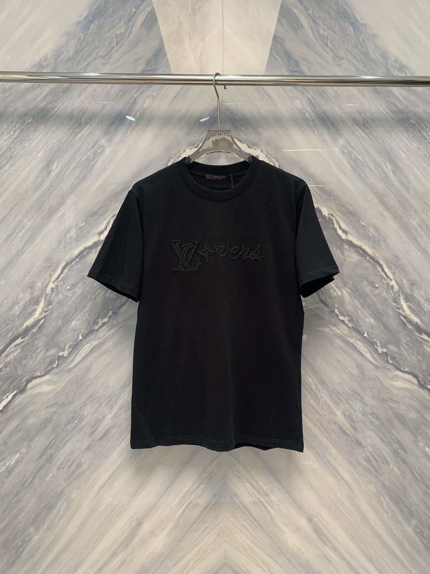 NO:419327,New spring and summer products are delicate craftsmanship, excellent quality 1V ten thousand needle embroidery logo round neck cotton short-sleeved T-shirt. This ten thousand needle embroidery logo round neck cotton short-sleeved T-shirt is a must-have item in summer wardrobe. First of all, the clothing is made of 100% pure cotton material, soft and breathable, giving the skin a gentle touch, suitable for all skin types, and it feels comfortable even if worn for a long time.  The neckline design adopts a classic round neck style, which is not only simple and elegant, but also can modify the neck lines just right, suitable for wearing in various occasions. The threading of the cuffs and hem adds the durability and overall beauty of the clothes. The most prominent is the logo design in front of the clothing, which adopts ten thousand needle embroidery technology. Each line is meticulous and meticulous, demonstrating the high-end and texture of the brand. The embroidery pattern is three-dimensional and full, and the color matching is harmonious, which not only enhances the overall visual aesthetics, but also shows the wearer's unique taste. Color: Black Size: S-2XL S: Bust 102 Length 71 Shoulder width 45 Sleeve length 23 M: Bust 106 Length 72 Shoulder width 46 Sleeve length 23 L: Bust 110 Length 73 Shoulder width 47 Sleeve length 23 XL: Bust 114  Clothes length 74 shoulder width 48 sleeve length 23 XXL: bust 118 Clothes length 75 shoulder width 49 sleeve length 23, T-shirt,tees,t-shirt,alexander wang19860909春夏新品细腻工艺,卓越品质1V万针刺绣logo圆领棉质短袖T恤,这款万针刺绣logo圆领棉质短袖T恤,是夏季衣橱的必备佳品.首先,服饰采用百分百纯棉材质,柔软透气,给予肌肤轻柔触感,适合各种肤质,即使长时间穿着也倍感舒适. 领口设计上采用了经典的圆领款式,不仅简约大方,还能恰到好处地修饰颈部线条,适合各种场合穿着.袖口与下摆的走线精细工整,增添了衣物的耐穿性与整体美观.最为突出的是服饰正前方的logo设计,采用了万针刺绣工艺,每一根线条都细致入微,彰显品牌的高端与质感.刺绣图案立体饱满,色彩搭配和谐,不仅提升了整体的视觉美感,也展现了穿着者的独特品味. 颜色:黑色 尺寸:S-2XL S: 胸围102 衣长71 肩宽45 袖长23  M: 胸围106 衣长72 肩宽46 袖长23  L: 胸围110 衣长73 肩宽47 袖长23  XL: 胸围114 衣长74 肩宽48 袖长23  XXL: 胸围118 衣长75 肩宽49 袖长23,,T-shirt,tees，t-shirt,alexander wang,Men's clothing