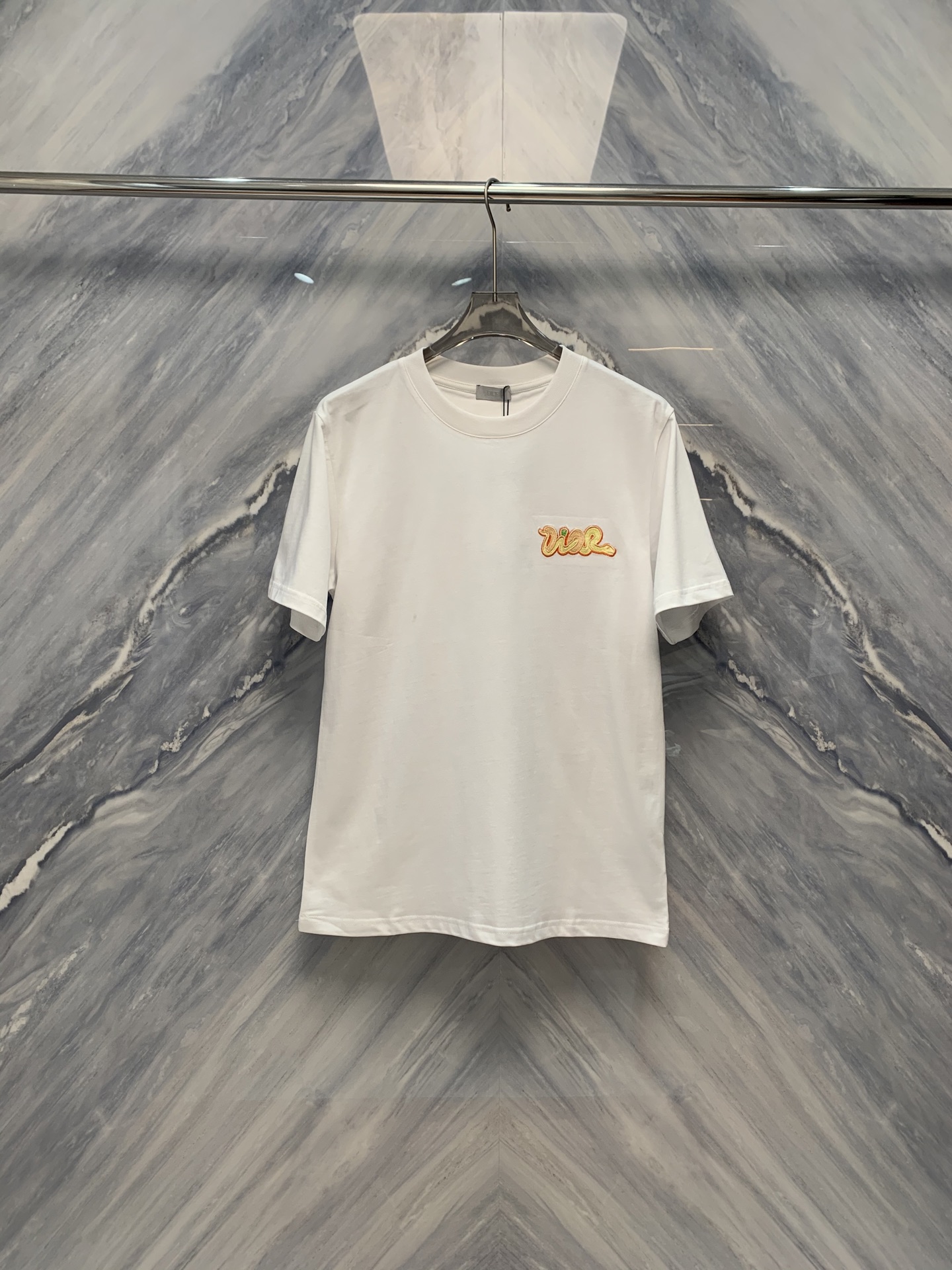 NO:419393,The new 25 spring and summer new product is a CD-needle embroidered round neck cotton short-sleeved T-shirt that combines delicate craftsmanship and comfortable wear. The CD-needle embroidered round neck cotton short-sleeved T-shirt is ingenious in detail processing, showing excellent craftsmanship and comfortable wearing experience. From the perspective of material, this T-shirt is made of pure cotton fabric, which is skin-friendly and soft, breathable and sweat-absorbing, providing a comfortable wearing basis for hot summer. The classic round neck design is simple and elegant, suitable for wearing in all occasions. Whether it is daily leisure or traveling, it can be easily controlled.  The most eye-catching thing is its ten-needle embroidery process. The embroidery surface is smooth and smooth, the stitches are fine and even, and each part shows high-quality details. The embroidery thread is soft and the color is saturated, which contrasts with pure cotton fabrics, highlighting the exquisiteness and three-dimensionality of the embroidery. Whether it is the brand logo or the artistic pattern, it can be vividly lifelike under ten-needle embroidery, showing a unique artistic charm. In terms of layout design, this T-shirt focuses on the application of ergonomic principles, fits without being tight, giving the body full of free space for movement. At the same time, the classic solid color design is matched with exquisite embroidery, adding a simple but not simple fashion sense. Color: White Size: S-2XL S: Bust 104 Length 71 Shoulder width 45 Sleeves 23 M: Bust 108 Length 72 Shoulder width 46 Sleeves 24 L:  Bust 112 Length 73 Shoulder width 47 Sleeve length 25 XL: Bust 116 Length 74 Shoulder width 48 Sleeve length 26 XXL: Bust 120 Length 75 Shoulder width 49 Sleeve length 27, T-shirt,tees,t-shirt,alexander wang1986090925春夏新品细腻工艺与舒适穿着相结合的CD艺术万针刺绣圆领棉质短袖T恤,CD艺术万针刺绣圆领棉质短袖T恤在细节处理上可谓匠心独运,展现了卓越的工艺水平和舒适的穿着体验.从材质上看,这款T恤采用纯棉面料,亲肤柔软,透气吸汗,为炎炎夏日提供了舒适的穿着基础.经典的圆领设计,简约大方,适合各种场合穿着.无论是日常休闲还是外出旅游,都能轻松驾驭. 而最为引人注目的便是其万针刺绣工艺.绣面平整顺滑,针脚细密均匀,每一处都彰显着高品质的细节处理.绣线光泽柔和,色彩饱和,与纯棉面料形成鲜明对比,更凸显出绣花的精致与立体感.无论是品牌标志还是艺术图案,都能在万针刺绣下栩栩如生,展现出独特的艺术魅力.在版型设计上,这款T恤注重人体工学原理的运用,合身而不紧绷,给予身体充分的自由活动空间.同时,经典的纯色设计搭配精致的刺绣,更添一份简约而不简单的时尚感. 颜色:白色 尺寸:S-2XL S: 胸围104 衣长71 肩宽45 袖长23  M: 胸围108 衣长72 肩宽46 袖长24 L: 胸围112 衣长73 肩宽47 袖长25 XL: 胸围116 衣长74 肩宽48 袖长26 XXL: 胸围120 衣长75 肩宽49 袖长27,,T-shirt,tees，t-shirt,alexander wang,Men's clothing