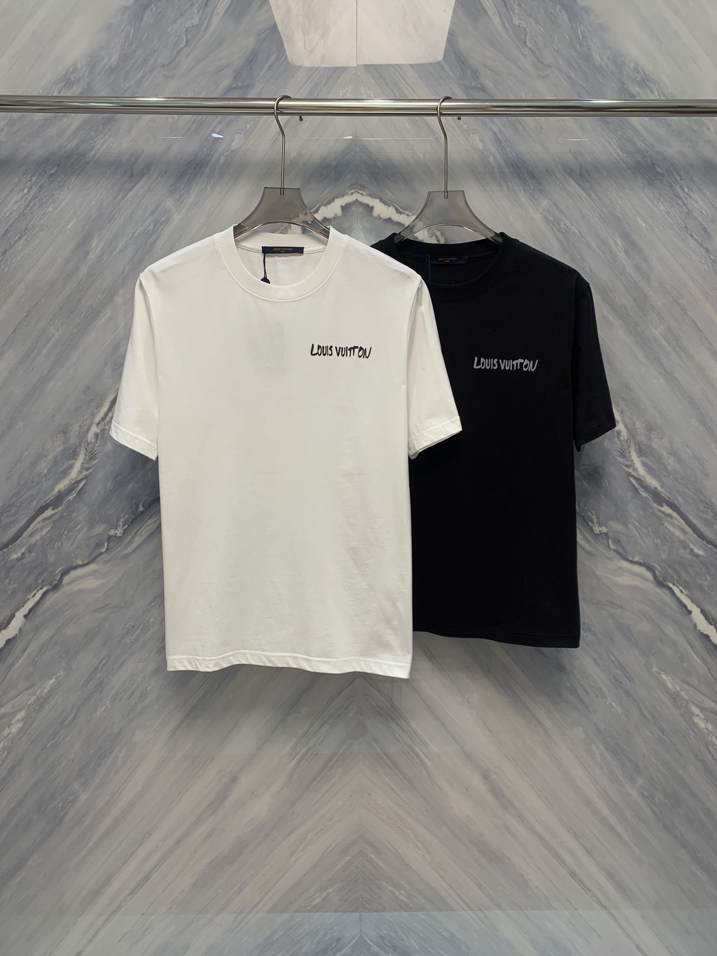 NO:419257,The new 1V cotton round neck artistic letter graffiti short-sleeved T-shirt in spring and summer is a must-have item in summer wardrobe. It uses high-tight woven cotton fabric, which feels soft and breathable, ensuring the comfort of wearing. The T-shirt is slightly loose in style, suitable for all figures, and with a thickened neckline design, it is more casual and durable. The details show the quality. The back collar to the shoulder adopts the full-cover chain double-line craft of this cloth to fit the skin and make it more comfortable to wear. The design is simple but not without fashion. The handwritten ACT continuous strokes of the brand logo are printed on the front, showing a unique artistic atmosphere. The classic combination of white and black and gray allows this T-shirt to be easily matched with various bottoms, while the dark green makes it more personalized and can make you stand out from the crowd. Color: Black White S-2XL S: Bust 104 Length 71 Shoulder width 44  Sleeve length 23 M: Bust 108 Clothes 72 Clothes 45 Clothes 24 L: Bust 112 Clothes 73 Clothes 46 Clothes 25 XL: Bust 116 Clothes 74 Clothes 47 Clothes 26 XXL: Bust 120 Clothes 75 Clothes 48 Clothes 27 Sleeve length 27, T-shirt,tees,t-shirt,alexander wang1986090925春夏新品1V棉质圆领艺术字母涂鸦短袖T恤是夏季衣橱中的必备单品.它采用高密紧织的棉质面料,手感柔软且透气性极佳,保证了穿着的舒适度.T恤的版型微宽松,适合各种身材,加之加厚领口设计,更加休闲耐穿. 细节之处更是彰显品质,后领到肩部采用本布全包条锁链双线工艺,贴合皮肤,穿着更加舒适.设计上简洁而不失时尚感,正面印有品牌logo的手写体ACT连笔字,展现出独特的艺术气息.白色和黑灰色的经典搭配,让这款T恤可以轻松搭配各种下装,深绿色则更显个性,能让你在人群中脱颖而出. 颜色:黑色 白色 尺寸:S-2XL S: 胸围104 衣长71 肩宽44 袖长23  M: 胸围108 衣长72 肩宽45 袖长24  L: 胸围112 衣长73 肩宽46 袖长25  XL: 胸围116 衣长74 肩宽47 袖长26  XXL: 胸围120 衣长75 肩宽48 袖长27,,T-shirt,tees，t-shirt,alexander wang,Men's clothing