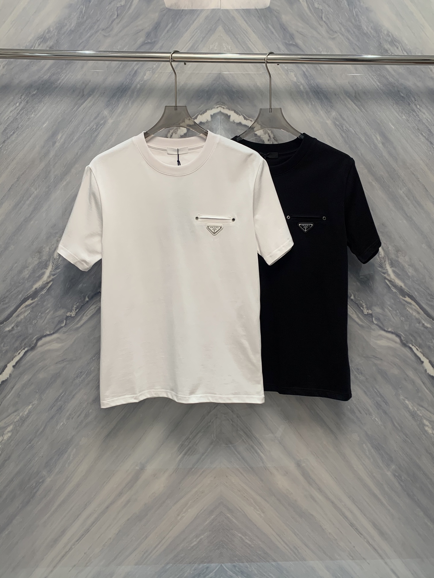 NO:419287,The new OEM factory order for the Lada metal inverted triangle cotton round neck men's short-sleeved T-shirt with its unique design and excellent material has become a must-have item in men's wardrobe in summer. This T-shirt is made of pure cotton fabric, soft and comfortable, with excellent breathability, suitable for all skin types, and can remain refreshed even in hot summers. Secondly, the designer carefully handles the details of the neckline, using a classic round neck design, which fits the curve of the neck, making it easy to put on and take off, and at the same time shows a simple and generous style.  In terms of pattern design, the front of the T-shirt is decorated with a metal texture inverted triangle pattern, breaking the monotony of the traditional T-shirt and adding a sense of fashion and dynamic. The inverted triangle pattern is not only unique in design, but also exquisite in workmanship, reflecting the wearer's taste and personality. In addition, the T-shirt's style is loose and moderate, suitable for various body shapes, which not only highlights the male casual and free temperament without losing the sense of fashion. Color: Black White Size: S-2XL S: Bust 102 Long 70 Shoulder width 44 Sleeve length 24 M: Bust 106 Long 71 Shoulder width 45 Sleeve length 25 L: Bust 110 Long 72 Shoulder width 46 Sleeve length 26 XL: Bust 114 Long 73 Shoulder width 47 Sleeve length 27 XXL: Bust 118 Long 74 Shoulder width 48  Sleeve length 28, T-shirt,tees,t-shirt,alexander wang1986090925春夏新品代工厂订单拉达金属倒三角棉质圆领男款短袖T恤,以其独特的设计和优良的材质,成为夏季男士衣橱中的必备单品.这款T恤采用了纯棉面料,柔软舒适,透气性极佳,适合各种肤质,即使在炎热的夏天也能保持清爽.其次,设计师在领口细节上做了精心处理,采用经典的圆领设计,贴合颈部曲线,穿脱方便,同时展现出简洁大方的风格. 在图案设计上,该T恤正面饰有金属质感倒三角图案,打破了传统T恤的单调,增添了一份时尚与动感.倒三角图案不仅设计独特,且做工精致,体现出穿着者的品味与个性.此外,T恤的版型宽松适度,适合各种体型,既能凸显出男性随性洒脱的气质,又不失时尚感. 颜色:黑色 白色 尺寸:S-2XL S: 胸围102 衣长70 肩宽44 袖长24  M: 胸围106 衣长71 肩宽45 袖长25  L: 胸围110 衣长72 肩宽46 袖长26  XL: 胸围114 衣长73 肩宽47 袖长27  XXL: 胸围118 衣长74 肩宽48 袖长28,,T-shirt,tees，t-shirt,alexander wang,Men's clothing