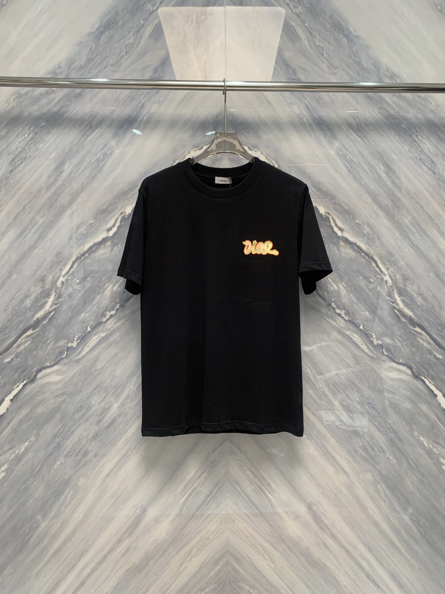 NO:419447,The new 25 spring and summer new product is a CD-needle embroidered round neck cotton short-sleeved T-shirt that combines delicate craftsmanship and comfortable wear. The CD-needle embroidered round neck cotton short-sleeved T-shirt is ingenious in detail processing, showing excellent craftsmanship and comfortable wearing experience. From the perspective of material, this T-shirt is made of pure cotton fabric, which is skin-friendly and soft, breathable and sweat-absorbing, providing a comfortable wearing basis for hot summer. The classic round neck design is simple and elegant, suitable for wearing in all occasions. Whether it is daily leisure or traveling, it can be easily controlled.  The most eye-catching thing is its ten-needle embroidery process. The embroidery surface is smooth and smooth, the stitches are fine and even, and each part shows high-quality details. The embroidery thread is soft and the color is saturated, which contrasts with pure cotton fabrics, highlighting the exquisiteness and three-dimensionality of the embroidery. Whether it is the brand logo or the artistic pattern, it can be vividly lifelike under ten-needle embroidery, showing a unique artistic charm. In terms of layout design, this T-shirt focuses on the application of ergonomic principles, fits without being tight, giving the body full of free space for movement. At the same time, the classic solid color design is matched with exquisite embroidery, adding a simple but not simple fashion sense. Color: Black Size: S-2XL S: Bust 104 Length 71 Shoulder width 45 Sleeves 23 M: Bust 108 Length 72 Shoulder width 46 Sleeves 24 L:  Bust 112 Length 73 Shoulder width 47 Sleeve length 25 XL: Bust 116 Length 74 Shoulder width 48 Sleeve length 26 XXL: Bust 120 Length 75 Shoulder width 49 Sleeve length 27, T-shirt,tees,t-shirt,alexander wang1986090925春夏新品细腻工艺与舒适穿着相结合的CD艺术万针刺绣圆领棉质短袖T恤,CD艺术万针刺绣圆领棉质短袖T恤在细节处理上可谓匠心独运,展现了卓越的工艺水平和舒适的穿着体验.从材质上看,这款T恤采用纯棉面料,亲肤柔软,透气吸汗,为炎炎夏日提供了舒适的穿着基础.经典的圆领设计,简约大方,适合各种场合穿着.无论是日常休闲还是外出旅游,都能轻松驾驭. 而最为引人注目的便是其万针刺绣工艺.绣面平整顺滑,针脚细密均匀,每一处都彰显着高品质的细节处理.绣线光泽柔和,色彩饱和,与纯棉面料形成鲜明对比,更凸显出绣花的精致与立体感.无论是品牌标志还是艺术图案,都能在万针刺绣下栩栩如生,展现出独特的艺术魅力.在版型设计上,这款T恤注重人体工学原理的运用,合身而不紧绷,给予身体充分的自由活动空间.同时,经典的纯色设计搭配精致的刺绣,更添一份简约而不简单的时尚感. 颜色:黑色 尺寸:S-2XL S: 胸围104 衣长71 肩宽45 袖长23  M: 胸围108 衣长72 肩宽46 袖长24 L: 胸围112 衣长73 肩宽47 袖长25 XL: 胸围116 衣长74 肩宽48 袖长26 XXL: 胸围120 衣长75 肩宽49 袖长27,,T-shirt,tees，t-shirt,alexander wang,Men's clothing