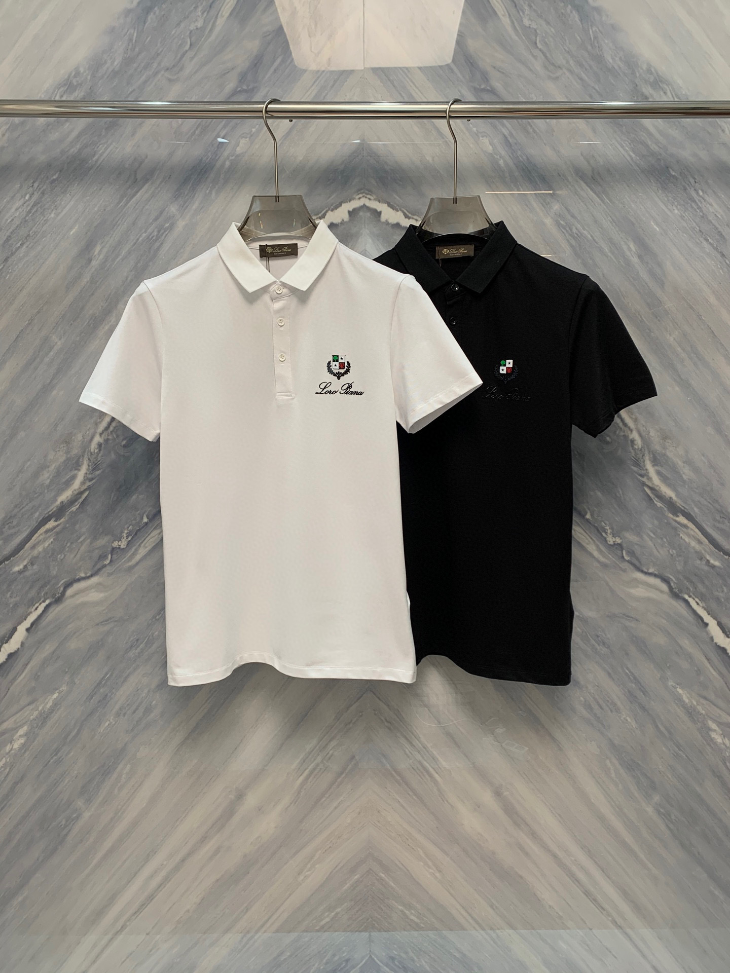NO:500485,25 spring and summer new OEM factory order Lao Qianfeng LP mercerated bead floor fabric lapel embroidered logo Polo shirt, perfectly blending classic design with luxurious texture, is an indispensable boutique in your wardrobe. The shirt body adopts a unique blend proportion and combined with exquisite merceration processing technology to make the surface of the fabric appear delicate luster, soft and excellent breathability, ensuring that it can be kept refreshing and comfortable in the hot summer.  The classic lapel design is not only elegant and durable, but also fits the neckline and shows the wearer's spirit. Each of the fine buttons on the neckline and cuffs has been carefully selected and customized, and the details show the brand's persistent pursuit of quality. The embroidered logo on the left chest is the finishing touch of the entire Polo shirt. The exquisite patterns and delicate stitches show the brand's excellent craftsmanship. The colors and fabrics are harmoniously integrated, which not only demonstrate the brand's identity, but also low-key luxury. Color: Black White Size: M-3XL M: Bust 98 Length 68 Length 42 Length 20 Length 102 Length 69 Length 43 Length 21 XL: Bust 106 Length 70 Length 44 Length 22 XXL: Bust 110 Length 71 Length 45 Length  Sleeve length 23 3XL: bust 114 garment length 72 shoulder width 46 sleeve length 24, loro piana, alexander wang1986090925春夏新品代工厂订单老钱风LP丝光珠地面料翻领刺绣logo Polo衫,将经典设计与奢华质感完美融合,是您衣橱中不可或缺的精品.衫身采用独特混纺比例,结合精湛的丝光处理技术,使面料表面呈现出细腻的光泽,触感柔软且具有极佳的透气性,确保在炎炎夏日中也能保持清爽舒适. 经典的翻领设计不仅优雅耐看,更贴合颈部线条,展现穿着者的精神风貌.领口与袖口的精细纽扣,每一颗都经过精心挑选与定制,细节之处尽显品牌对品质的执着追求.而位于左胸的刺绣logo,则是整件Polo衫的点睛之笔,精致的图案与细腻的针脚彰显着品牌的卓越工艺,色彩与面料和谐相融,既彰显品牌身份,又不失低调奢华. 颜色:黑色 白色 尺寸:M-3XL M: 胸围98 衣长68 肩宽42 袖长20  L: 胸围102 衣长69 肩宽43 袖长21  XL: 胸围106 衣长70 肩宽44 袖长22  XXL: 胸围110 衣长71 肩宽45 袖长23  3XL: 胸围114 衣长72 肩宽46 袖长24,,loro piana,alexander wang,Men's clothing