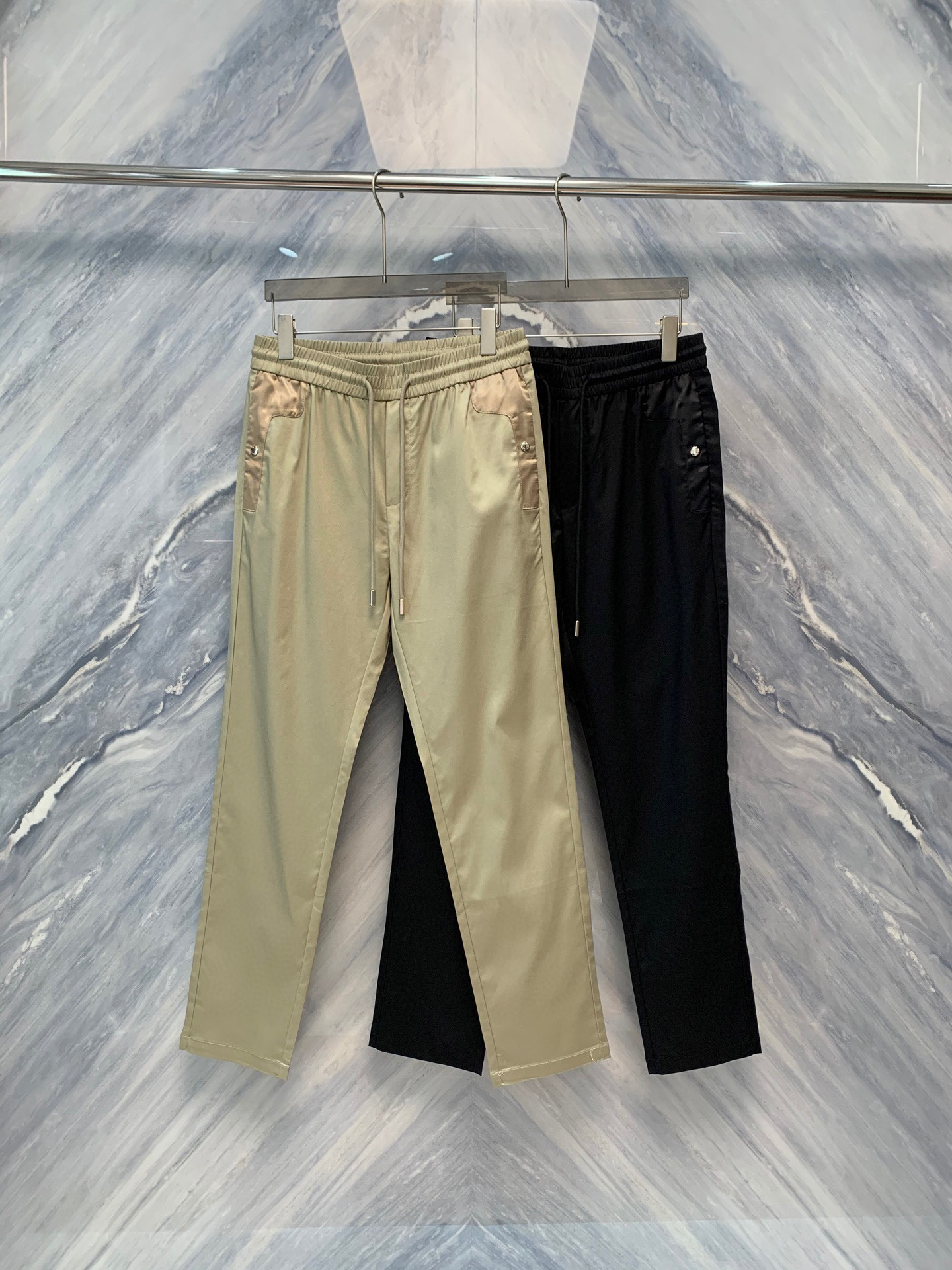 NO:500457,The new spring and summer OEM factory order Lada straight nylon interposer bag cotton straight trousers. This trousers are mainly made of cotton, comfortable and breathable, suitable for all seasons to wear. The nylon interposer part enhances wear resistance and fashion sense. The classic straight-fitting style, smooth lines of the trouser legs, can well modify the leg shape, suitable for all body shapes. The pocket design is unique, and the nylon interposer bag is both practical and adds visual highlights. The waist of the trouser waist is designed with custom buttons and drawstrings, which is convenient for putting on and off, and at the same time ensures stability during wear. The subtle closing design at the trouser legs effectively prevents the trouser legs from rolling up and maintains a neat appearance. Whether it is daily leisure or commuting office, Lada straight nylon interposer bag cotton straight trousers can be easily dealt with, showing the wearer's unique taste and fashion attitude. Color: Khaki Black Size M-3XL M: Waist circumference 74-80 Pants length 100  Hip circumference 100 L: Waist circumference 80-86 Pants length 101 Hip circumference 104 XL: Waist circumference 86-92 Pants length 102 Hip circumference 108 XXL: Waist circumference 92-98 Pants length 103 Hip circumference 112 XXXL: Waist circumference 98-104 Pants length 104 Hip circumference 116,,alexander wang19860909春夏新品代工厂订单拉达直筒尼龙拼接口袋棉质直筒长裤,这款长裤主要采用棉质材料,舒适透气,适合四季穿着.尼龙拼接部分增强了耐磨性和时尚感.经典的直筒版型,裤腿线条流畅,能够很好地修饰腿型,适合各种身材.口袋设计别具一格,尼龙拼接口袋既实用又增添视觉亮点. 裤腰采用定制纽扣与抽绳设计,方便穿脱,同时保证了穿着时的稳固性.裤脚处的细微收口设计,有效防止裤脚上卷,保持整洁外观.无论是日常休闲还是通勤办公,拉达直筒尼龙拼接口袋棉质直筒长裤都能轻松应对,展现出穿着者的独特品味与时尚态度. 颜色:卡其色 黑色 尺寸M-3XL M:腰围74-80 裤长100 臀围100  L:腰围80-86 裤长101 臀围104  XL:腰围86-92 裤长102 臀围108  XXL:腰围92-98 裤长103 臀围112  XXXL:腰围98-104 裤长104 臀围116,,alexander wang,Men's clothing