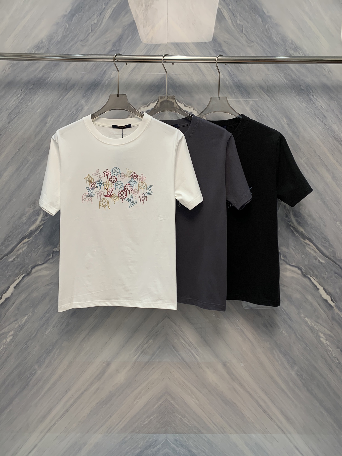 NO:419506,In the world of fashion, details determine success or failure. The 1V presbyopia colored diamond round neck high-weight cotton T-shirt has become a must-have item in summer wardrobe with its exquisite details and excellent quality. The clothing uses high-weight cotton fabric, which is soft and breathable, fits the skin, giving the wearer an ultimate comfort experience. The classic round neck design is simple and elegant, suitable for wearing in all occasions. The use of 1V presbyopia pattern adds a retro and luxurious atmosphere to the T-shirt.  It is worth mentioning that the carefully inlaid colored diamonds on the T-shirts flash with dazzling light, which not only enhances the overall fashion sense, but also highlights the wearer's unique taste. The details are true. The 1V presbyopia colored diamond round neck high gram heavy cotton T-shirt has become an indispensable fashion choice in summer with its exquisite details. Whether it is daily wear or important occasions, this T-shirt can easily become the focus. Choose a 1V presbyopia colored diamond round neck high gram heavy cotton T-shirt to add points to your charm. Color: Black White Gray Size: S-2XL S: Bust 102 Length 69 Shoulder width 45 Sleeve length 23 M: Bust 106 Length 70 Shoulder width 46 Sleeve length 24 L: Bust 110 Length 71 Shoulder width 47 Sleeve length 25 XL:  Bust 114 Clothes length 72 Shoulder width 48 Sleeve length 26 XXL: Bust 118 Clothes length 73 Shoulder width 49 Sleeve length 27,,tees,t-shirt,alexander wang19860909在时尚的世界里,细节决定成败.1V老花彩钻圆领高克重棉质T恤,以其精致的细节处理和卓越的品质,成为夏季衣橱的必备单品.服饰采用高克重棉质面料,柔软透气,贴合肌肤,给予穿着者极致的舒适体验.经典的圆领设计,简洁大方,适合各种场合穿着.而1V老花图案的运用,则为T恤增添了一份复古与奢华的气息. 值得一提的是,T恤上精心镶嵌的彩钻,在光线的照射下闪烁着耀眼的光芒,不仅提升了整体的时尚感,更彰显了穿着者的独特品味.细节之处见真章,1V老花彩钻圆领高克重棉质T恤,凭借其考究的细节处理,成为夏季不可或缺的时尚选择.无论是日常穿搭还是重要场合,这款T恤都能让你轻松成为焦点.选择1V老花彩钻圆领高克重棉质T恤,让细节之美为你的魅力加分. 颜色:黑色 白色 灰色 尺寸:S-2XL S: 胸围102 衣长69 肩宽45 袖长23  M: 胸围106 衣长70 肩宽46 袖长24  L: 胸围110 衣长71 肩宽47 袖长25  XL: 胸围114 衣长72 肩宽48 袖长26  XXL: 胸围118 衣长73 肩宽49 袖长27,,tees，t-shirt,alexander wang,Men's clothing