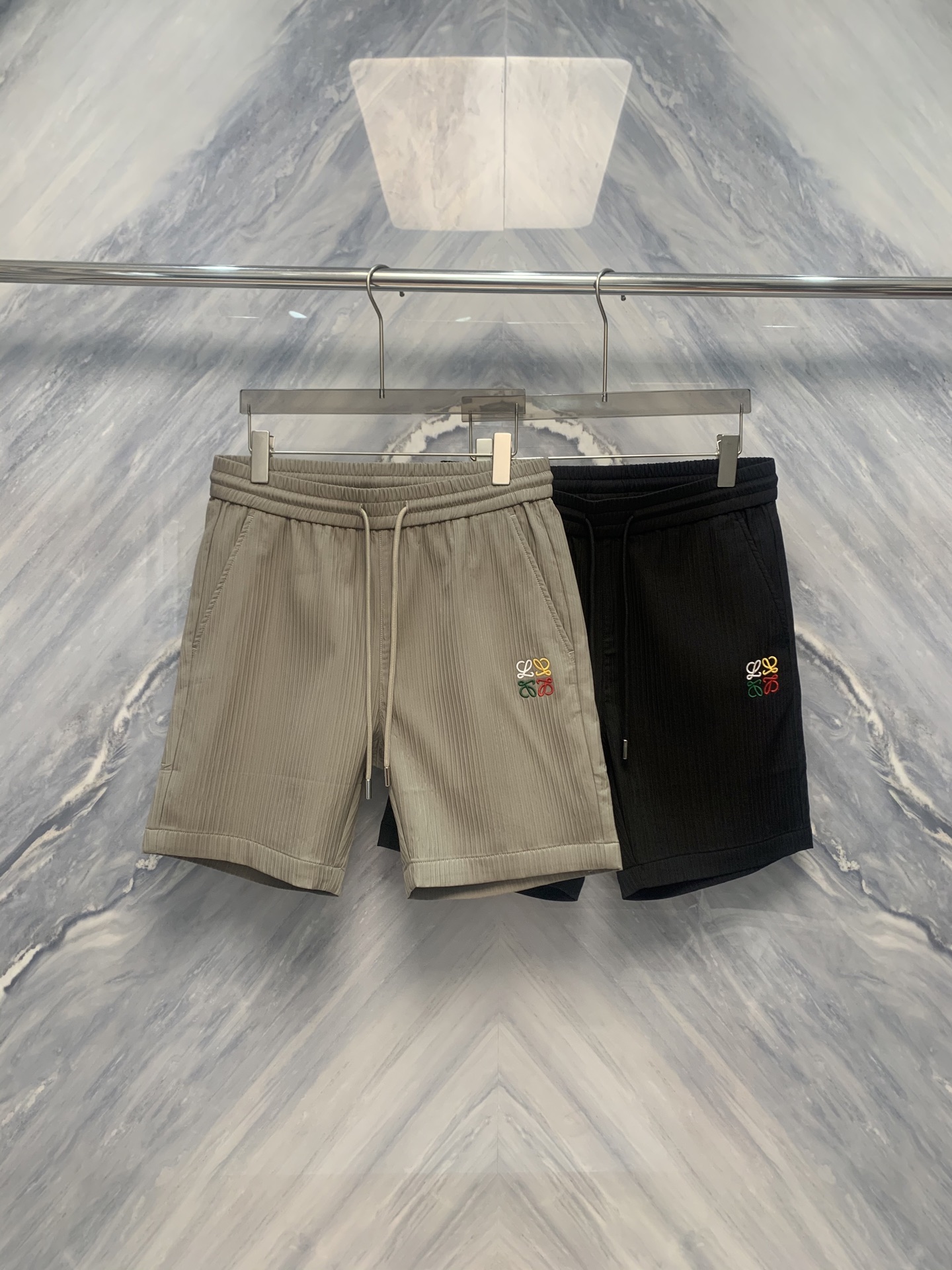 NO:500478,The new 25-spring and summer Luoshen Wan Needle Embroidery logo vertical striped design five-point sports shorts, combining fashion and comfort, is a perfect combination of sports and leisure. The most eye-catching details are the logo of Wan Needle Embroidery. The exquisite embroidery technology, fine stitches and strong three-dimensional sense, showing the nobleness and texture of the brand. Whether it is sports or daily wear, it can highlight the wearer's personality and taste. The shorts adopt vertical striped design, which visually lengthens the leg lines and looks longer. The density and width of the vertical stripes have been carefully designed, neither too dense nor sparse, which just enhances the overall fashion sense. The material of the shorts is breathable and sweat-absorbing high-tech fabric, which can quickly sweat and keep it dry. Whether it is hot summer or after strenuous exercise, it can be comfortable. Color: gray Black Size: M-3XL M: waist 72  Pants length 51 hip circumference 106 L: waist circumference 78 pants length 52 hip circumference 110 XL: waist circumference 84 pants length 53 hip circumference 114 XXL: waist circumference 90 pants length 54 hip circumference 118 XXXL: waist circumference 96 pants length 55 hip circumference 122,,shorts,alexander wang1986090925春夏新品罗神万针刺绣logo竖条纹设计五分运动短裤,集时尚与舒适于一体,是运动与休闲的完美结合短裤最引人注目的细节是万针刺绣的logo.精巧的刺绣工艺,针脚细密,立体感强,展现出品牌的高贵与质感.无论是运动还是日常穿着,都能彰显穿着者的个性与品味. 短裤采用竖条纹设计,视觉上拉长腿部线条,显得更加修长.竖条纹的密度和宽度经过精心设计,既不过于密集,也不会显得稀疏,恰到好处地提升了整体的时尚感.短裤的材质选用透气、吸汗的高科技面料,能够迅速排汗,保持干爽.无论是炎热的夏天还是剧烈运动后,都能保持舒适. 颜色:灰色 黑色 尺寸:M-3XL M: 腰围72 裤长51 臀围106  L: 腰围78 裤长52 臀围110  XL: 腰围84 裤长53 臀围114  XXL: 腰围90 裤长54 臀围118  XXXL: 腰围96 裤长55 臀围122,,shorts,alexander wang,Men's clothing