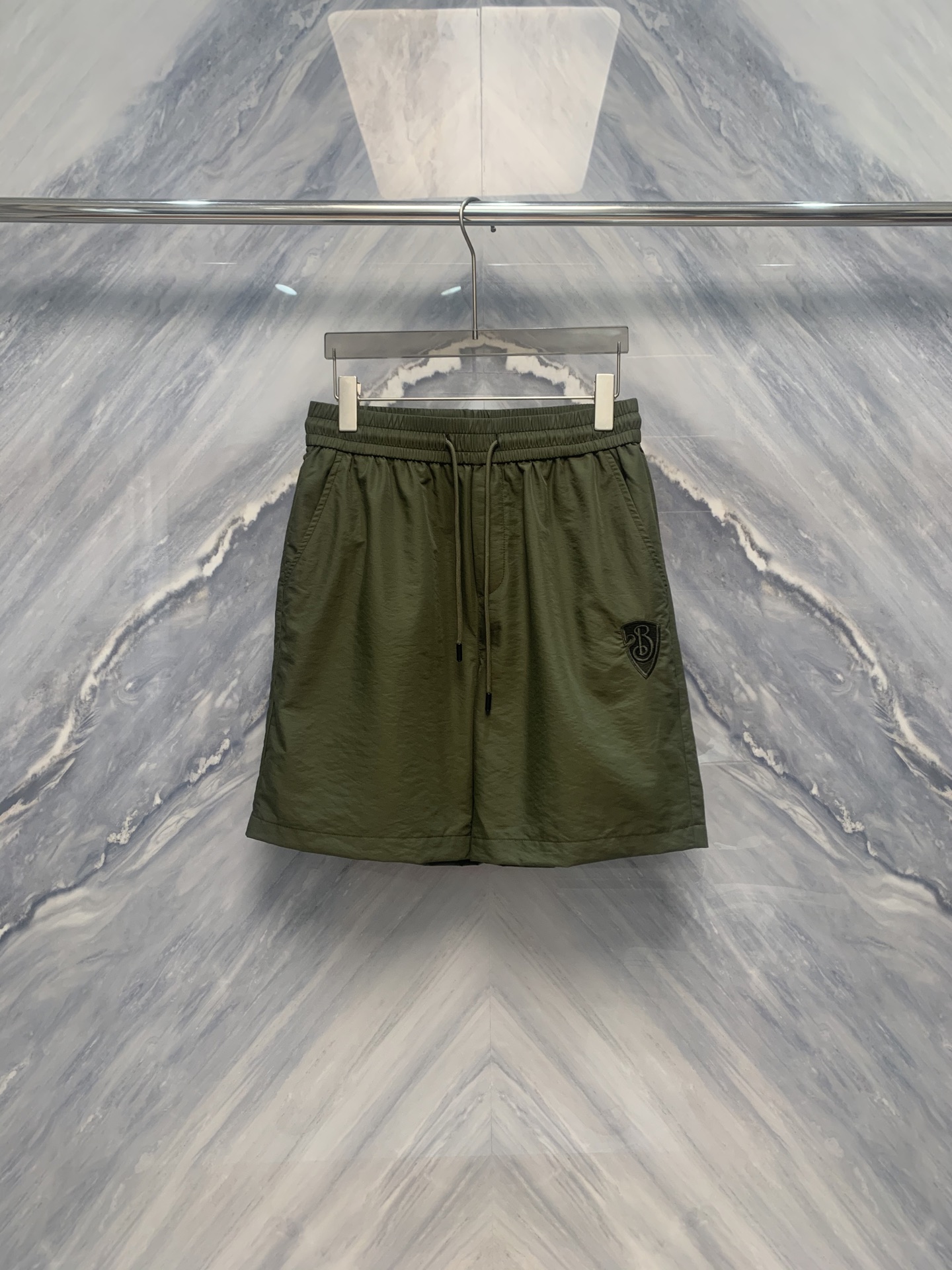 NO:500476,OEM factory order BBR war horse embroidery logo nylon five-point sports shorts, which is a perfect combination of brand classic and modern craftsmanship. First of all, the shorts are made of high-quality nylon material, light and breathable, suitable for various sports occasions. The details are even more exquisite. The war horse embroidery logo is located on the left side of the shorts. The embroidery workmanship is exquisite, and the image of the war horse is lifelike, showing the brand's unique design style. The waist of the shorts adopts a wide edge elastic design, which not only ensures comfort in wearing, but also is suitable for consumers of different body types. The trouser legs adopts a five-point design with a moderate length, neither too restricted nor too dragged. Whether it is daily wear or exercise, it can be easily controlled. Color: Green Size: M-3XL M: Waist circumference 72 Trouser 51 Hip circumference 106 L: Waist circumference 78 Trouser 52 Hip circumference 110 XL: Waist circumference 84 Trouser 53  Hip circumference 114 XXL: Waist circumference 90 Trousers length 54 Trousers length 118 XXXL: Waist circumference 96 Trousers length 55 Trousers length 122,,shorts,alexander wang19860909代工厂订单BBR战马刺绣logo尼龙材质五分运动短裤,是品牌经典与现代工艺的完美结合.首先,短裤采用高品质尼龙材质,轻盈透气,适合各种运动场合.细节之处更是精益求精,战马刺绣logo位于短裤左侧,绣工精湛,战马形象栩栩如生,展现了品牌独特的设计风格. 短裤腰部采用宽边松紧设计,既保证了穿着舒适度,又适合不同体型的消费者.裤脚处采用五分设计,长度适中,既不会过于束缚,也不会显得拖沓.无论是日常穿着还是运动健身,都能轻松驾驭. 颜色:绿色 尺寸:M-3XL M: 腰围72 裤长51 臀围106  L: 腰围78 裤长52 臀围110  XL: 腰围84 裤长53 臀围114  XXL: 腰围90 裤长54 臀围118  XXXL: 腰围96 裤长55 臀围122,,shorts,alexander wang,Men's clothing