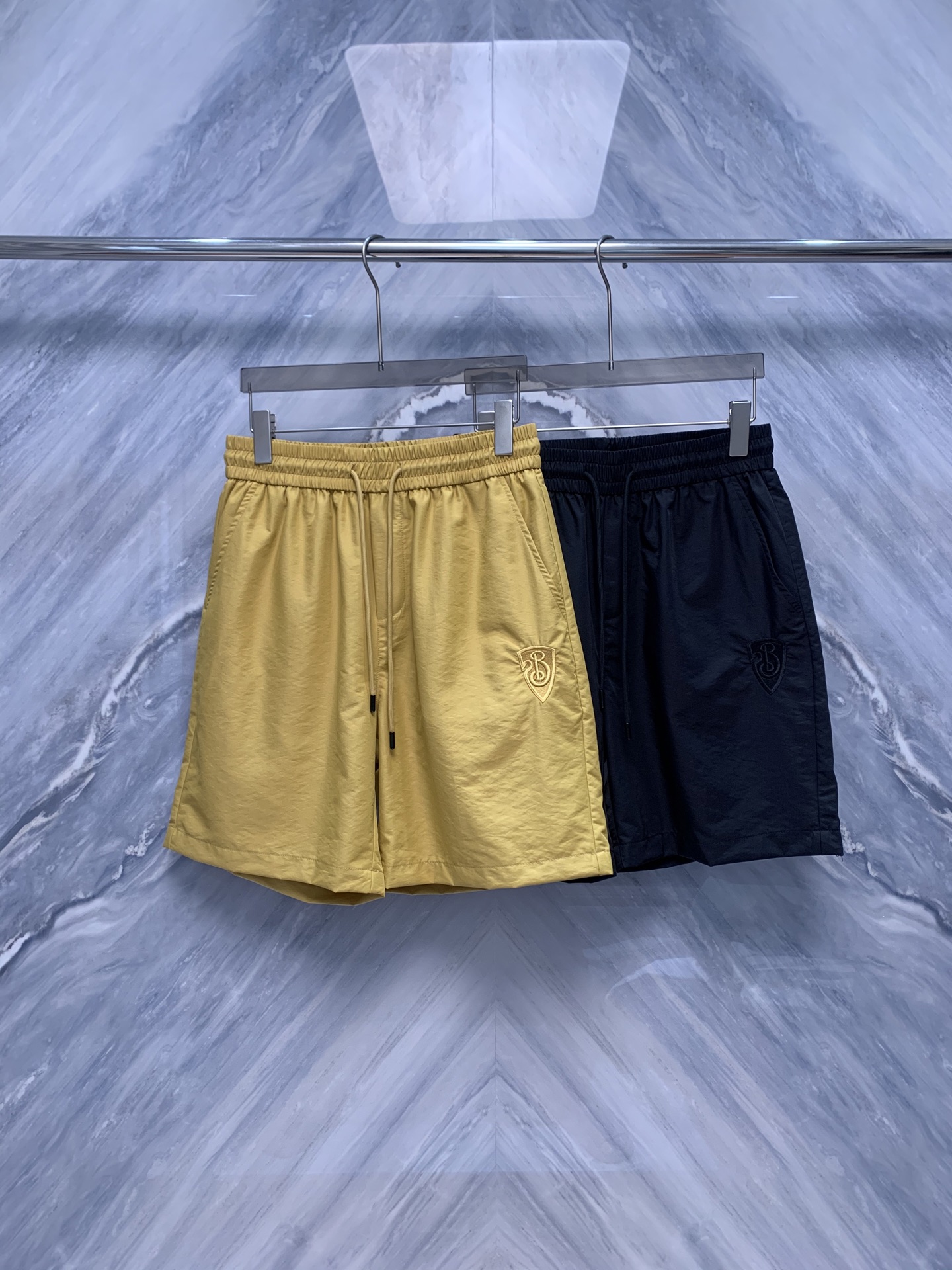 NO:500472,OEM factory order BBR war horse embroidery logo nylon material is a perfect combination of brand classic and modern craftsmanship. First of all, the shorts are made of high-quality nylon material, light and breathable, suitable for various sports occasions. The details are even more exquisite. The war horse embroidery logo is located on the left side of the shorts. The embroidery workmanship is exquisite, and the image of the war horse is lifelike, showing the brand's unique design style. The waist of the shorts is made of wide edges, which not only ensures comfort in wearing, but also is suitable for consumers of different body types. The legs of the trouser are designed with a moderate length, neither too restricted nor too dragged. Whether it is daily wear or exercise, it can be easily controlled. Color: black bright yellow Size: M-3XL M: waist 72 trouser length 51 hip 106 L: waist 78 trouser length 52 hip 110 XL: waist 84 trouser length 53 hip 114  XXL: Waist 90, trousers length 54, hip 118, XXXL: Waist 96, trousers length 55, hip 122,, shorts, alexander wang19860909代工厂订单BBR战马刺绣logo尼龙材是品牌经典与现代工艺的完美结合.首先,短裤采用高品质尼龙材质,轻盈透气,适合各种运动场合.细节之处更是精益求精,战马刺绣logo位于短裤左侧,绣工精湛,战马形象栩栩如生,展现了品牌独特的设计风格. 短裤腰部采用宽边松紧设计,既保证了穿着舒适度,又适合不同体型的消费者.裤脚处采用五分设计,长度适中,既不会过于束缚,也不会显得拖沓.无论是日常穿着还是运动健身,都能轻松驾驭. 颜色:黑色 明黄色 尺寸:M-3XL M: 腰围72 裤长51 臀围106  L: 腰围78 裤长52 臀围110  XL: 腰围84 裤长53 臀围114  XXL: 腰围90 裤长54 臀围118  XXXL: 腰围96 裤长55 臀围122,,shorts,alexander wang,Men's clothing